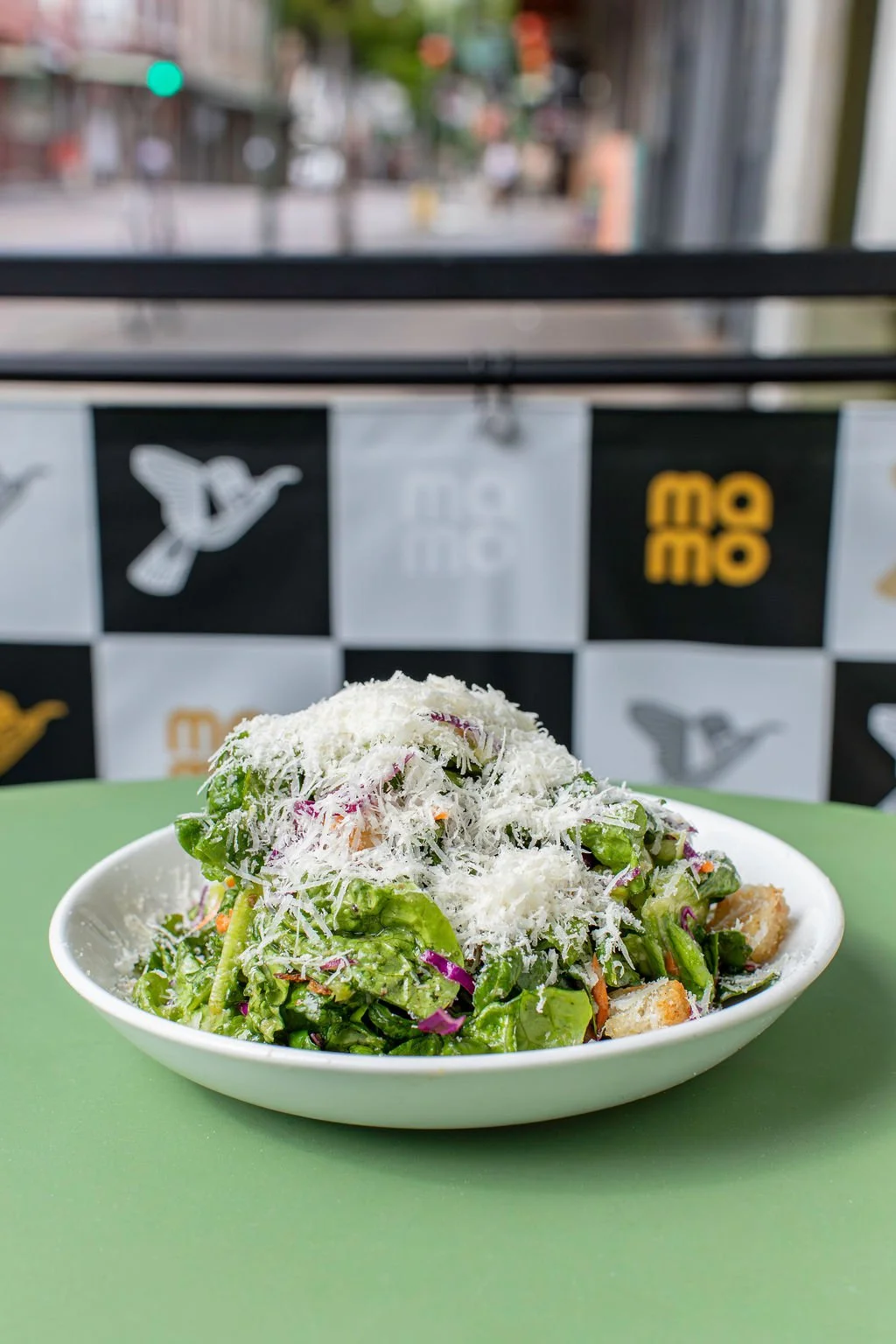 Pizza Mamo salad with fresh local ingredients on the outdoor lanai patio table in Honolulu Chinatown on Oahu
