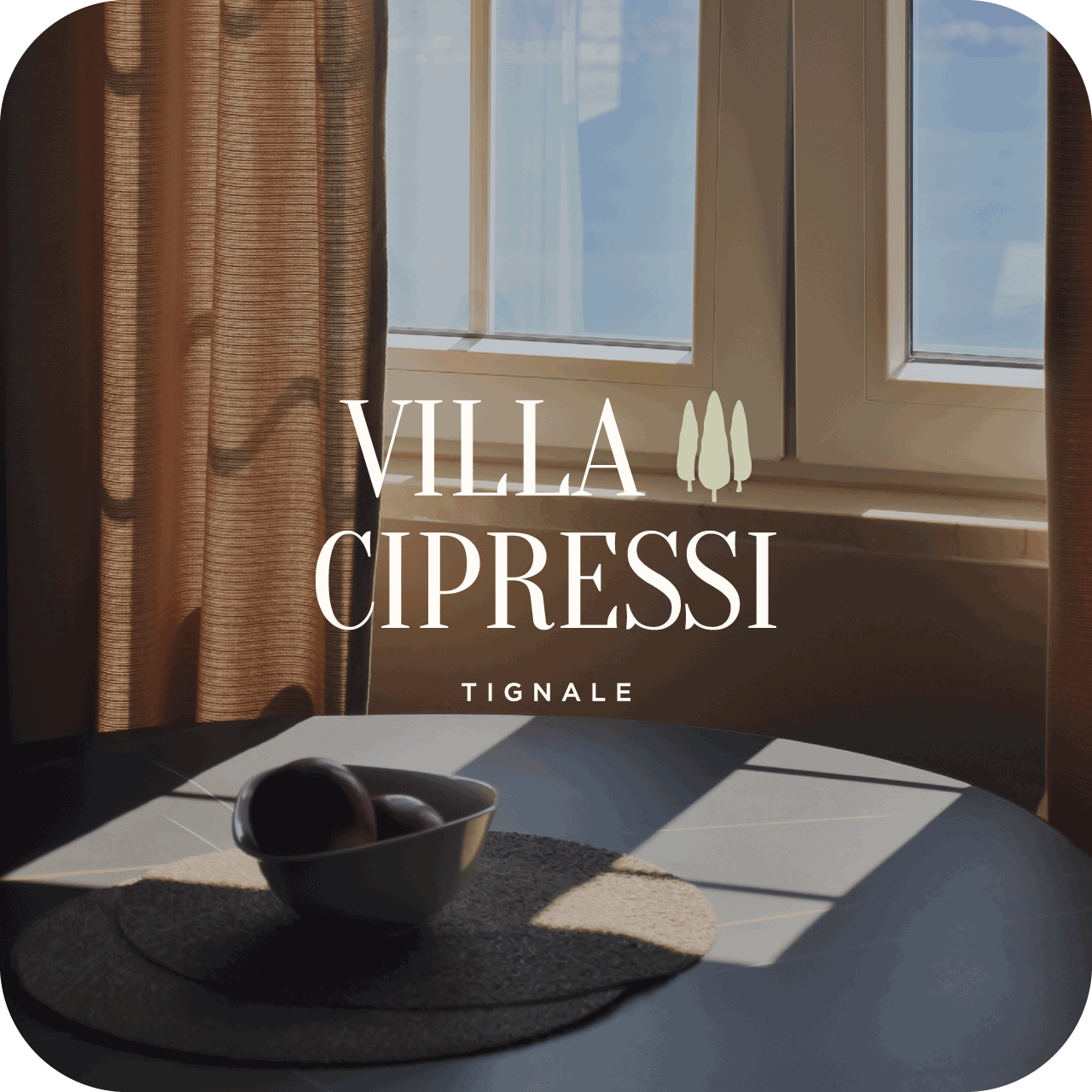 Wortmarke Villa Cipressi Tignale vor einem sonnendurchfluteten Wohnraum