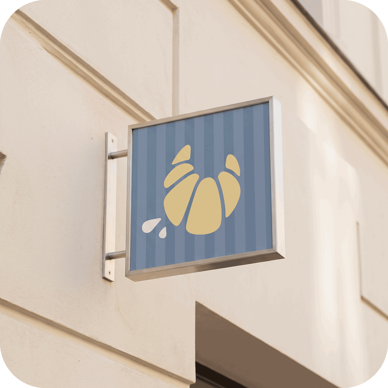 Ladenschild mit gelbem Croissant-Symbol an einer hellen Hausfassade