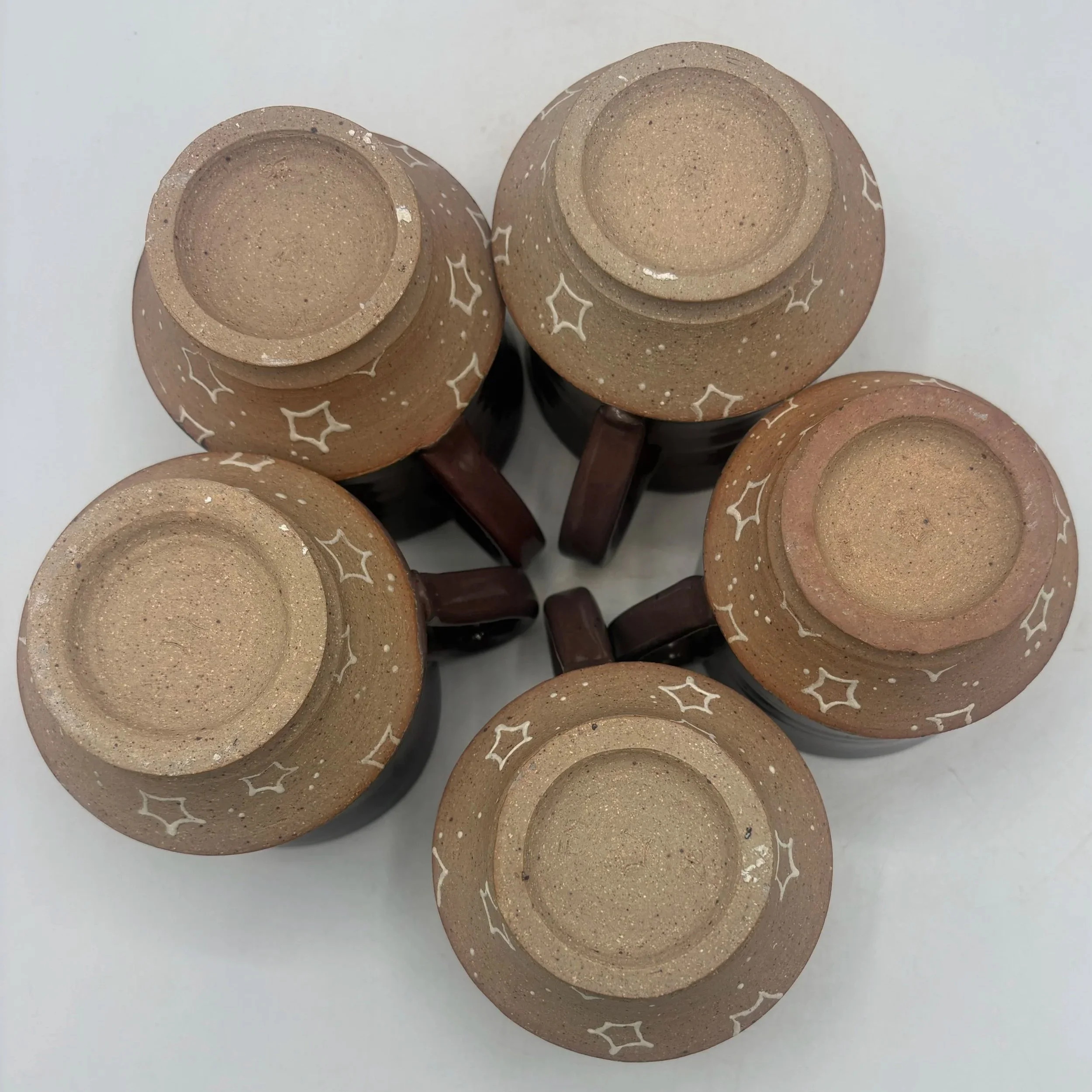 Wheel thrown and slip trailed mugs, fired to cone 06 reduction