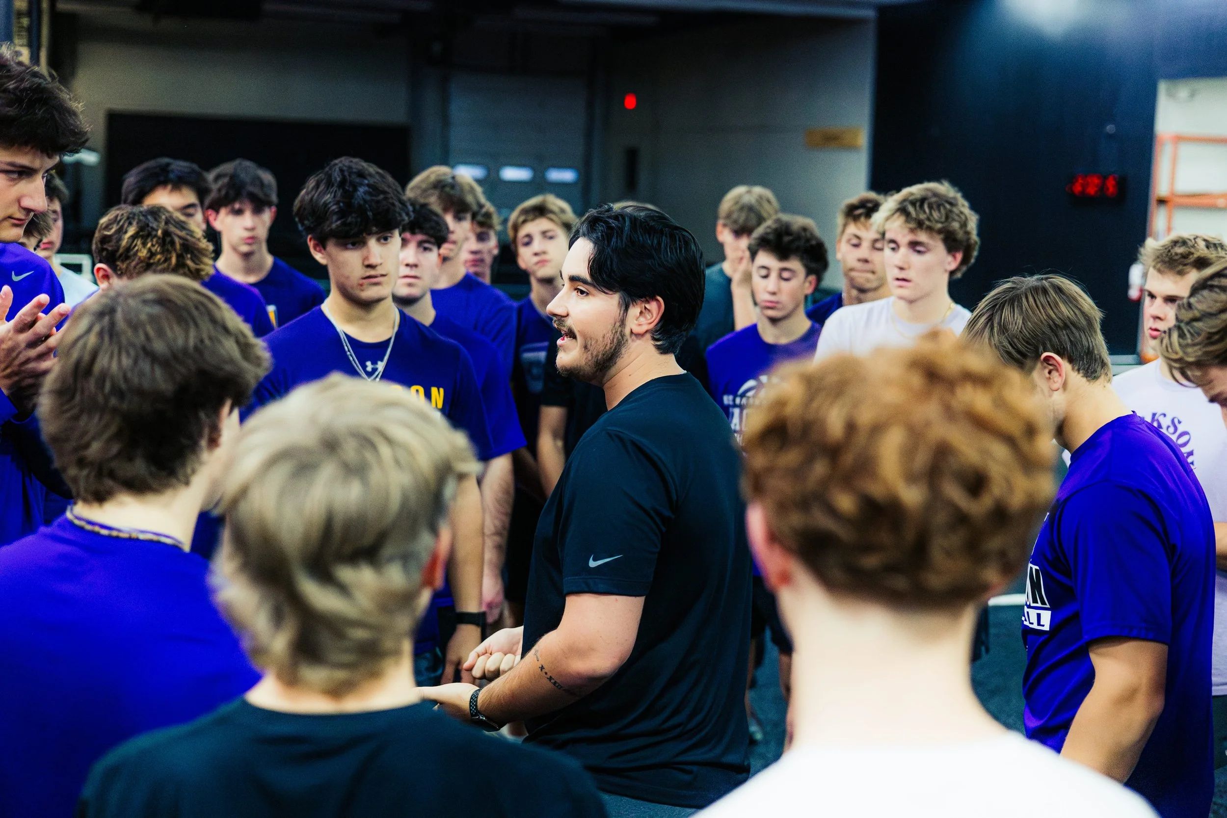 A group of young male athletes from Jackson Baseball listening to Nick LeMay, strength coach at Big Cat Performance after a workout.