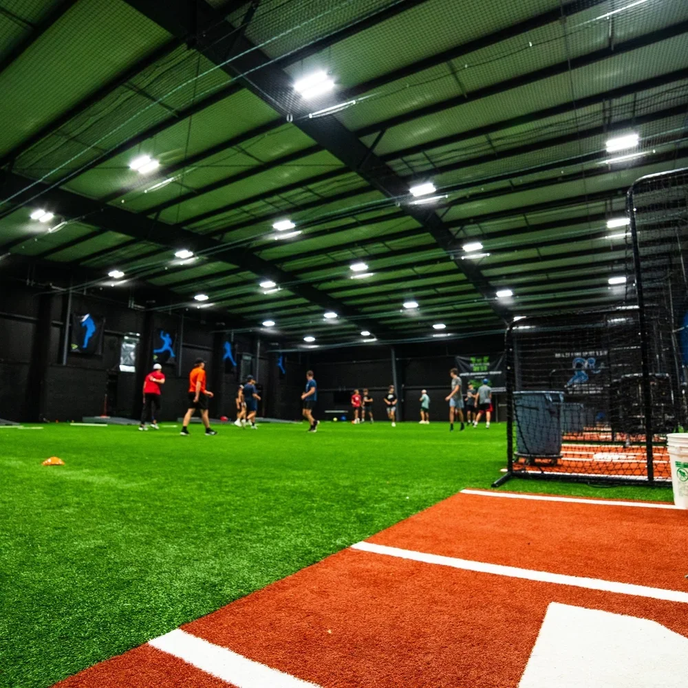 Velocity Sports in Canal Fulton, indoor sports training facility with artificial turf, players practicing, and batting cages.