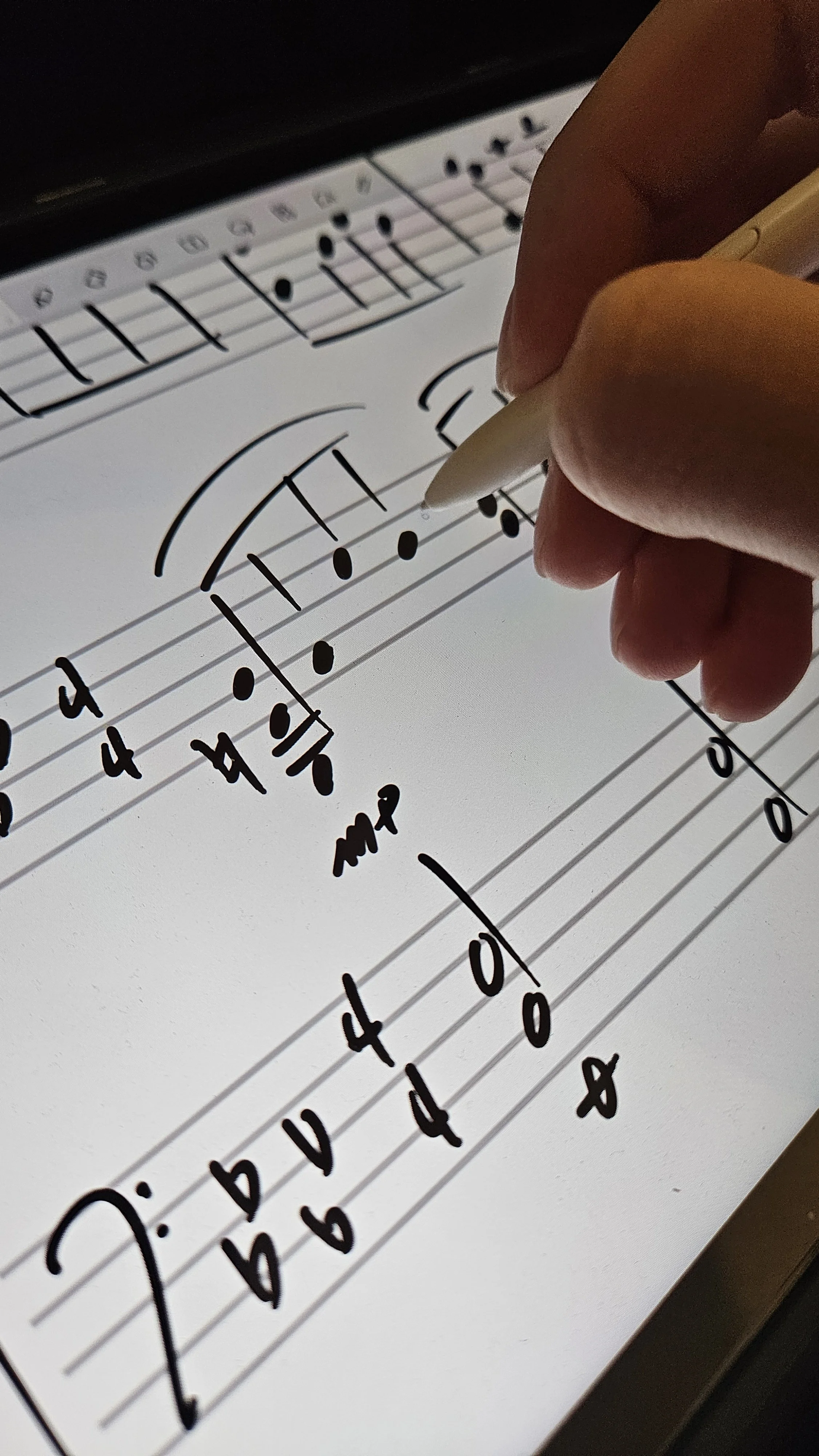 Digital sheet of music with handwritten notes and fingerings, showing a musical staff, notes, and finger number annotations, with a hand holding a stylus or pen.