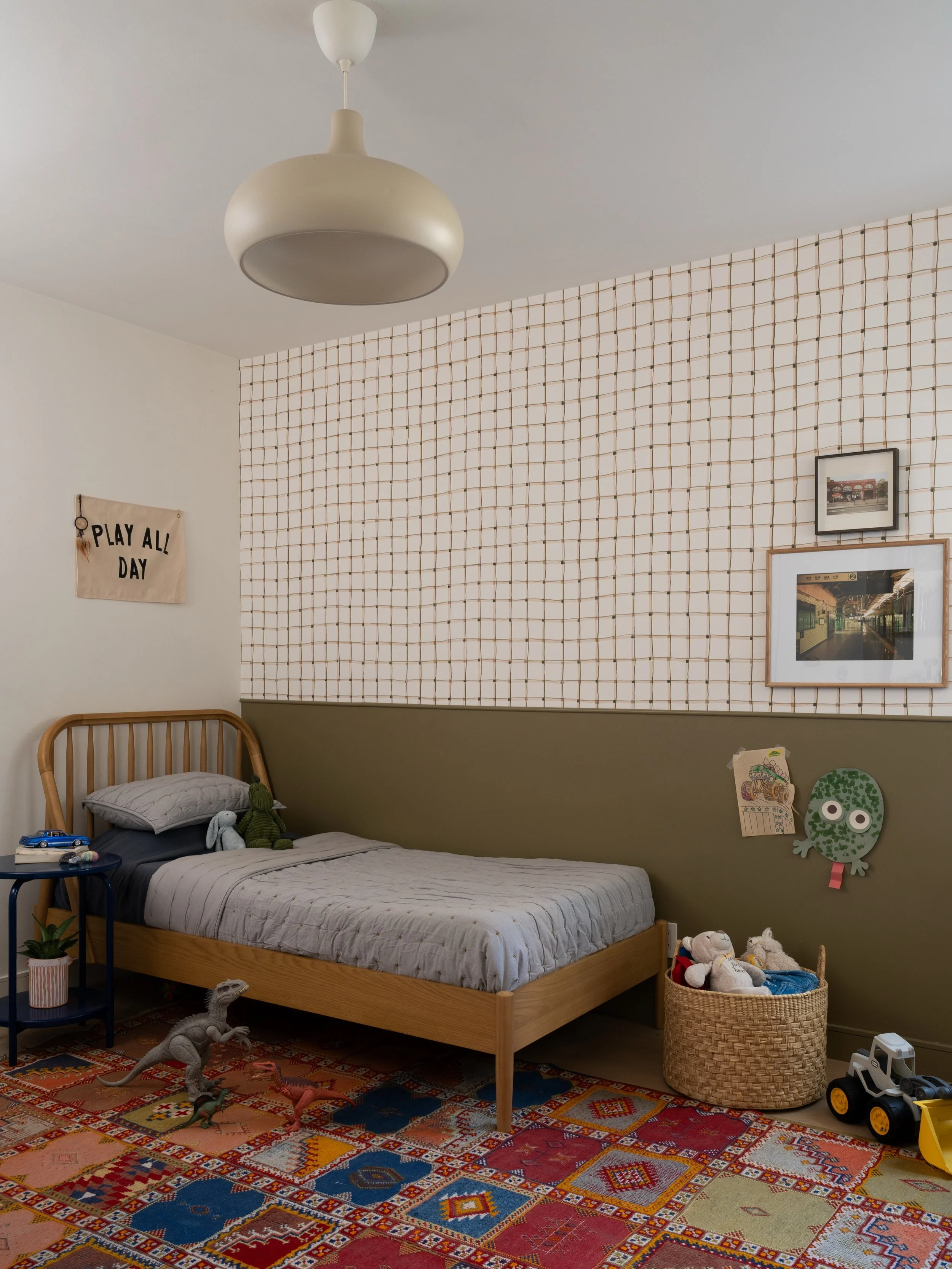 Taking color inspiration from the vintage rug, the olive green paint and wallpaper add just the right amount of fun into this kiddo&rsquo;s room. We added just a few new pieces that pull it all together and it&rsquo;s ready for playing, crafting, and