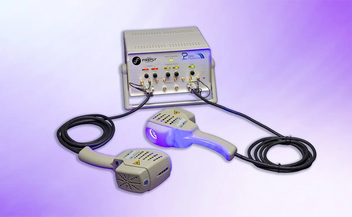 Firefly Light Therapy device with two wand, one emitting red and blue light, connected to a control unit with various switches and indicators, set against a purple background.