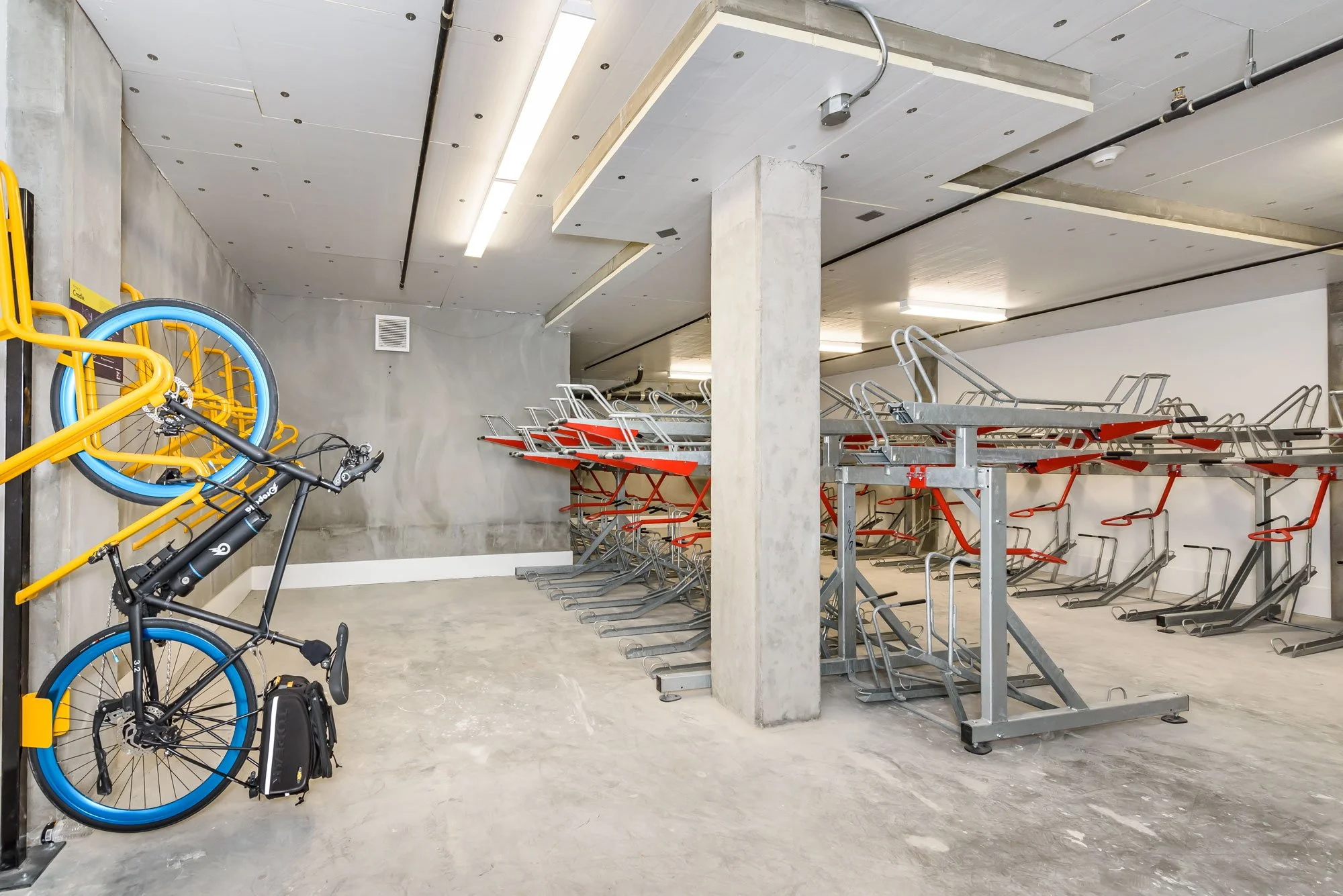 Empty underground parking garage with bicycles and bike racks.