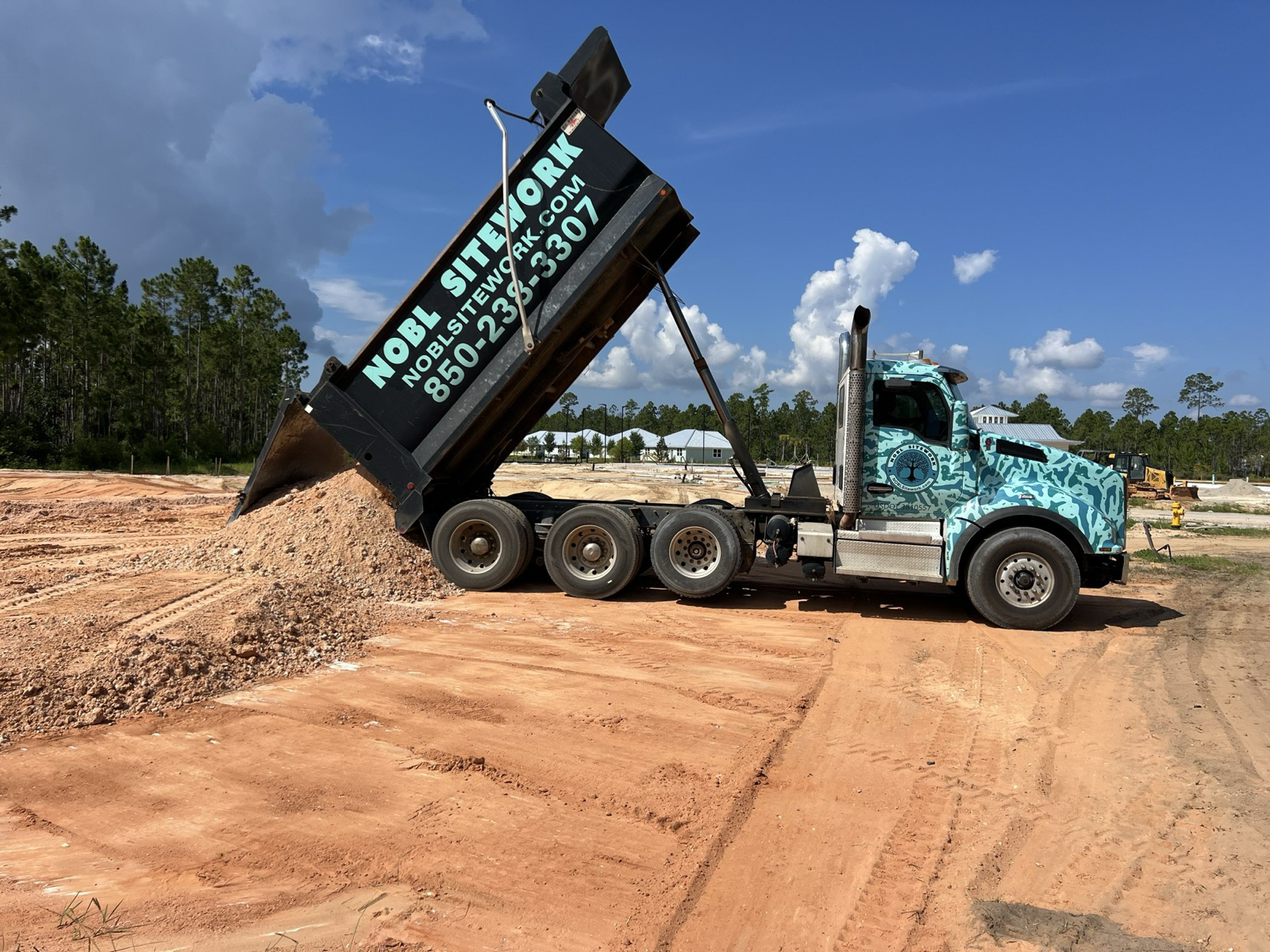 NOBL Sitework dump truck delivering a load of fill dirt to a jobsite in Northwest Florida