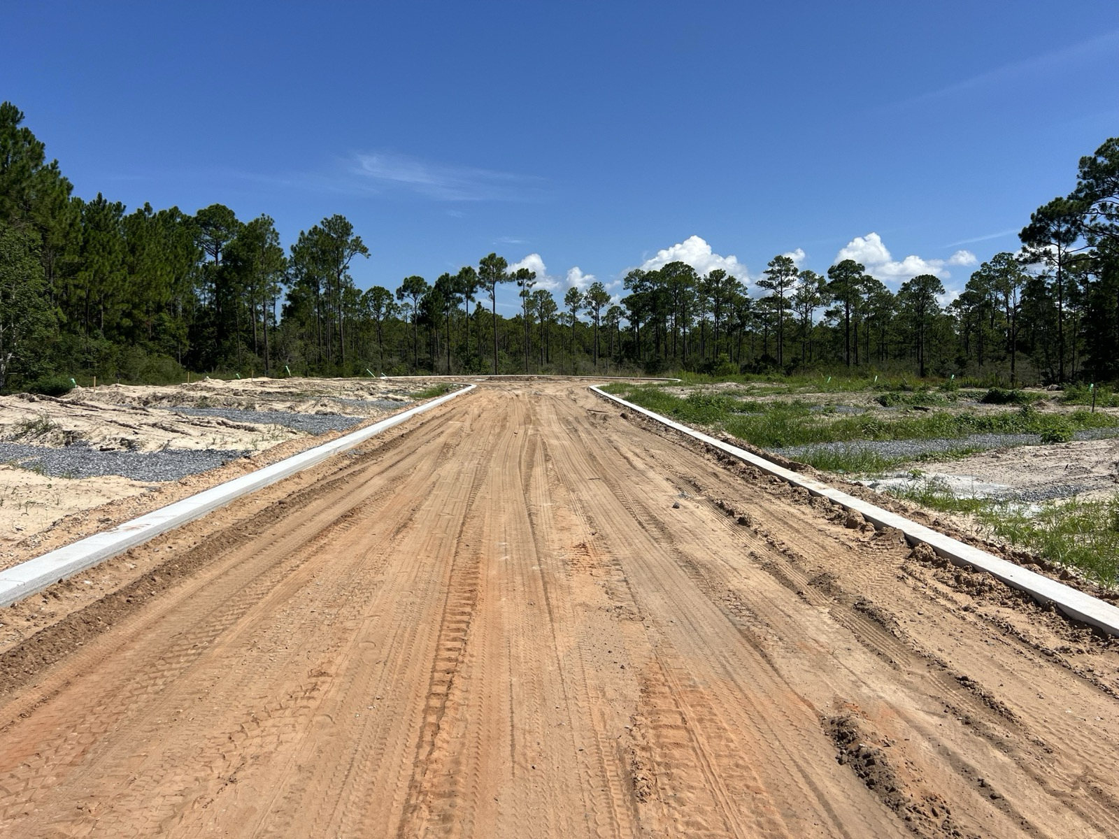 New road graded to final grade with curbs on a residential site development project in Northwest Florida