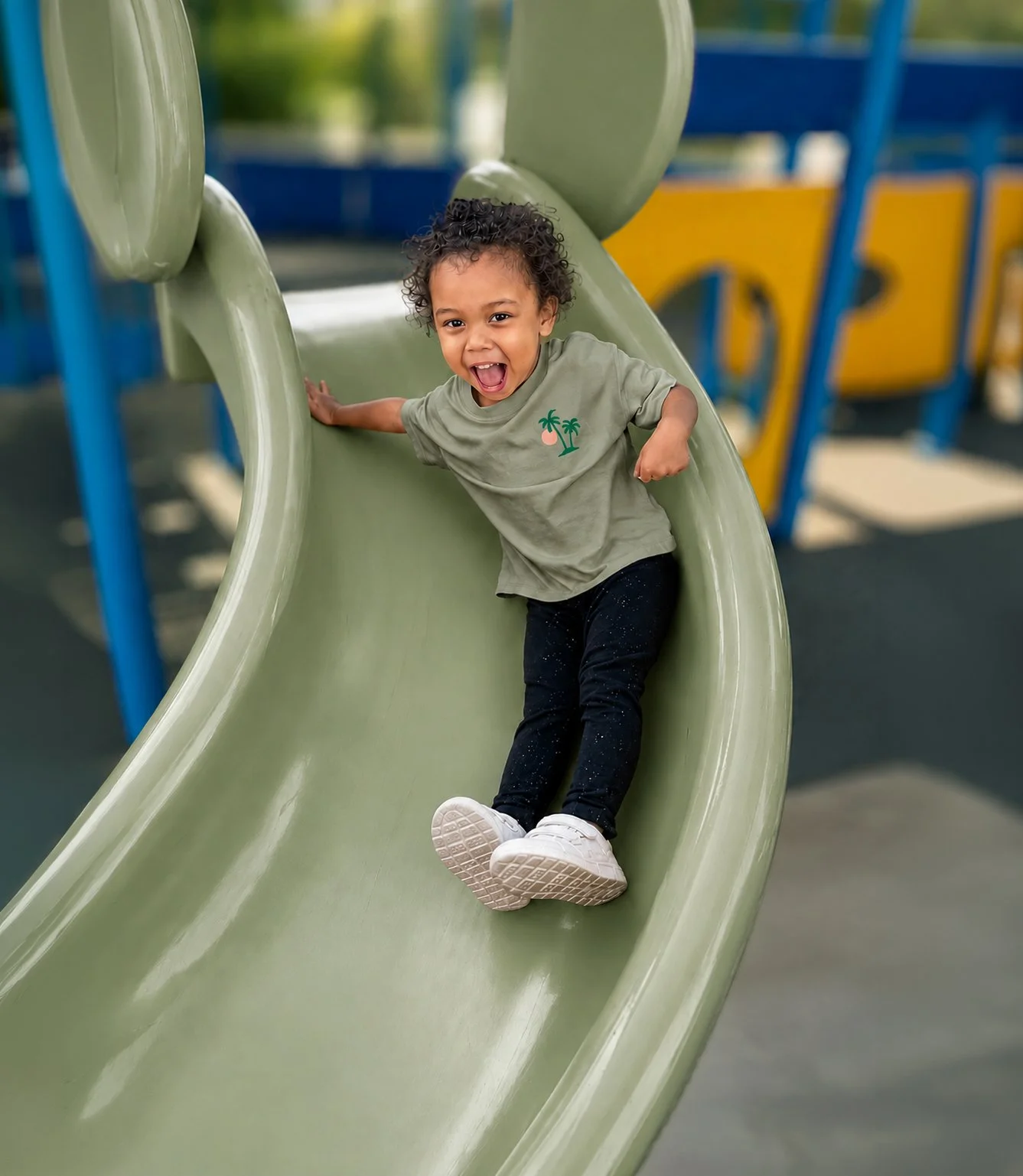 TOL-outside-play-littel-girl-green-slide.jpg