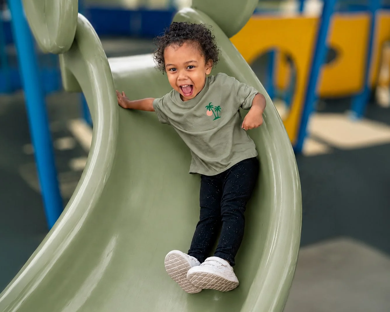 TOL-outside-play-littel-girl-green-slide-HOR.jpg