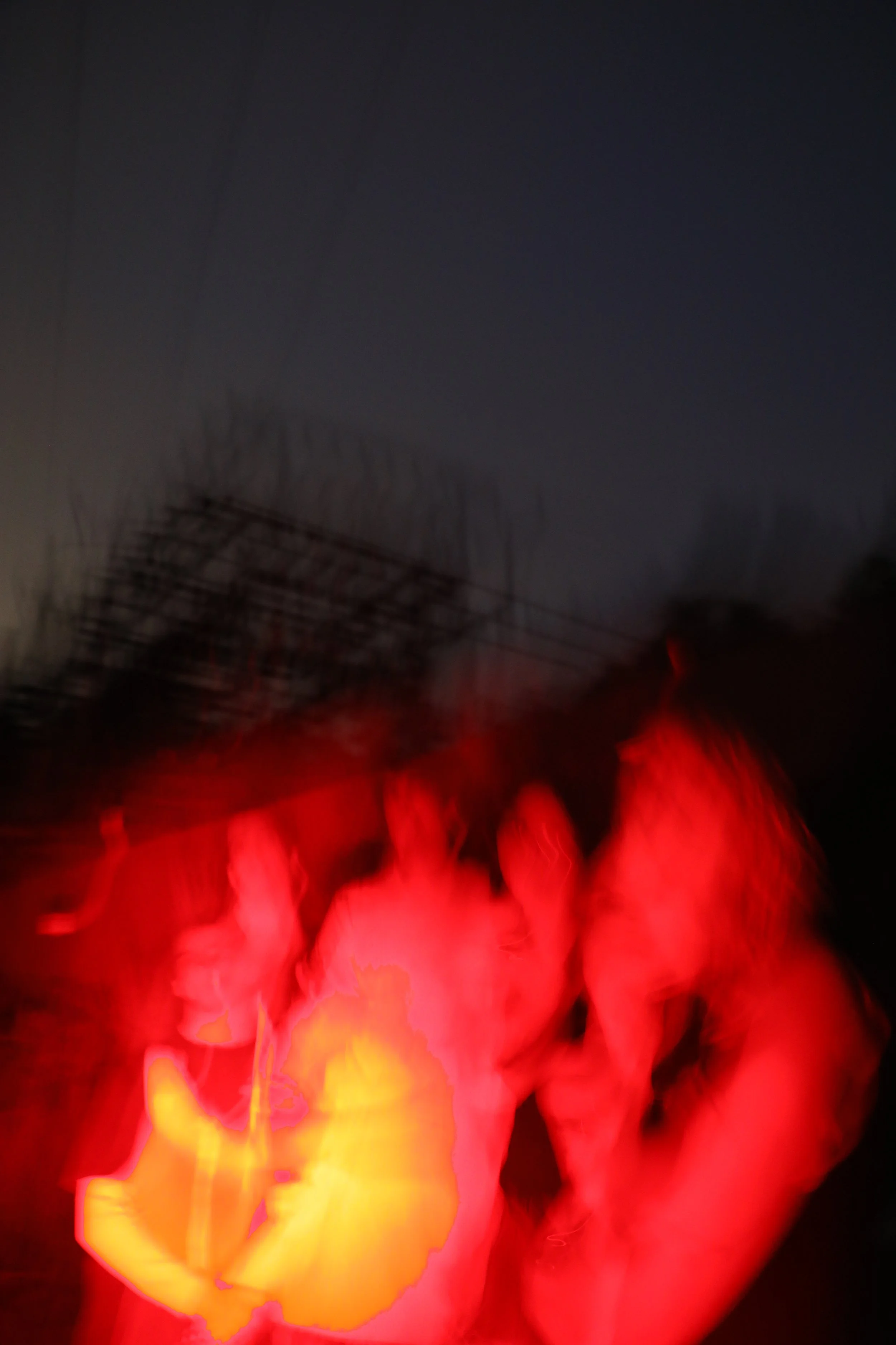 Bright glowing red, yellow, and orange sparks or fire in a dark environment