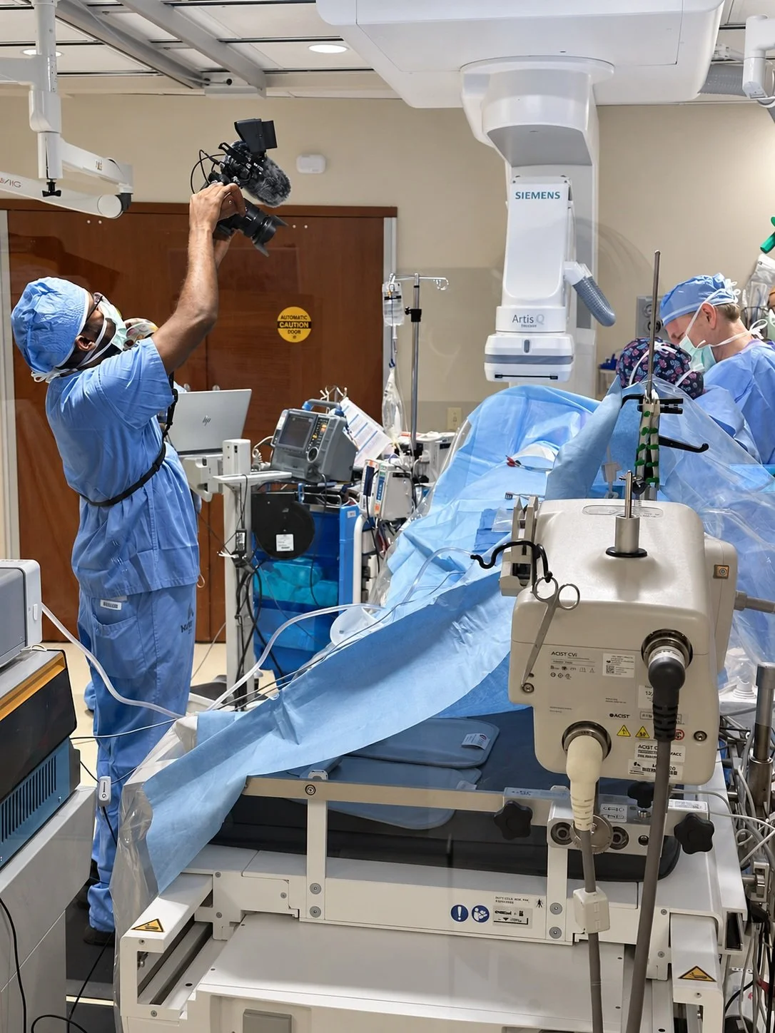 Behind the scenes of a clinical video production, with a camera operator filming overhead.