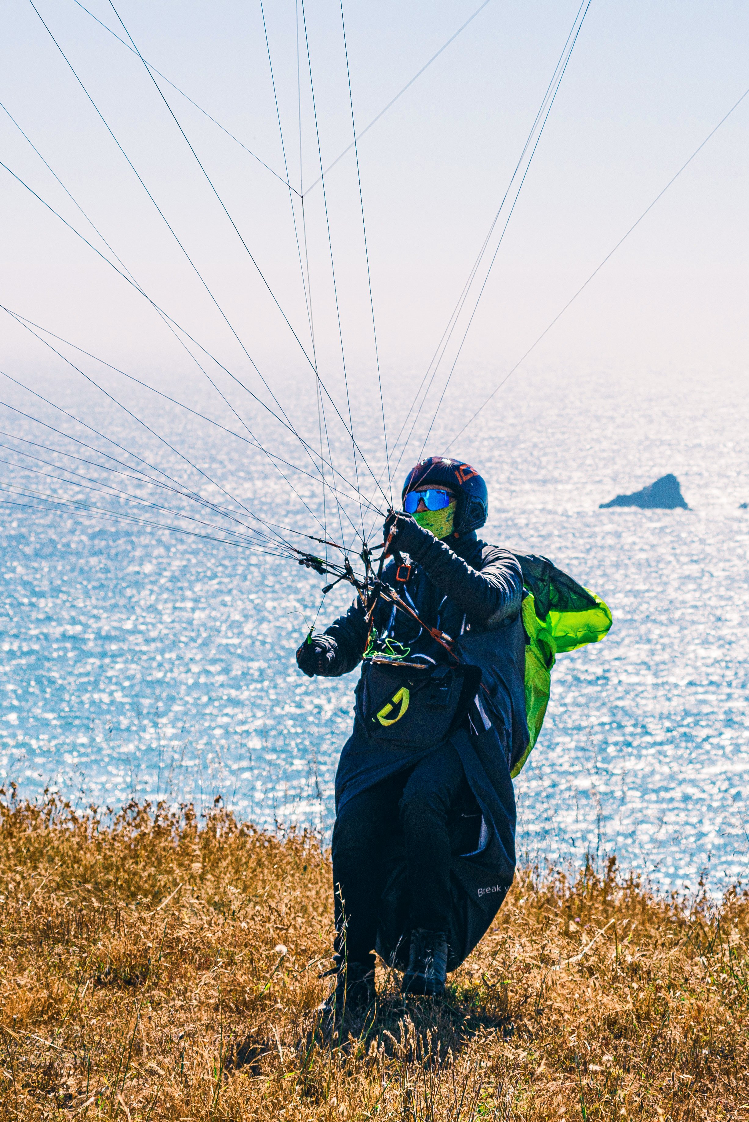 Anthony launching a paraglider at a coastal site in California