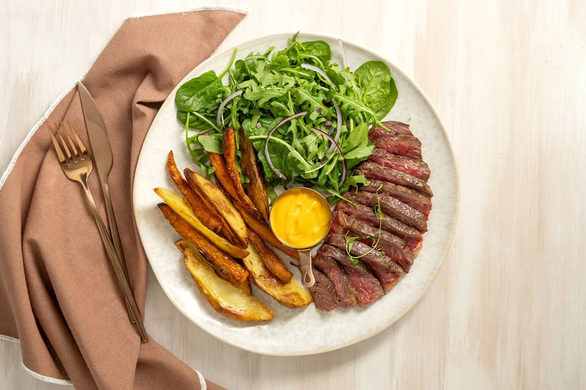 Sliced steak with bearnaise sauce, fries and green salad