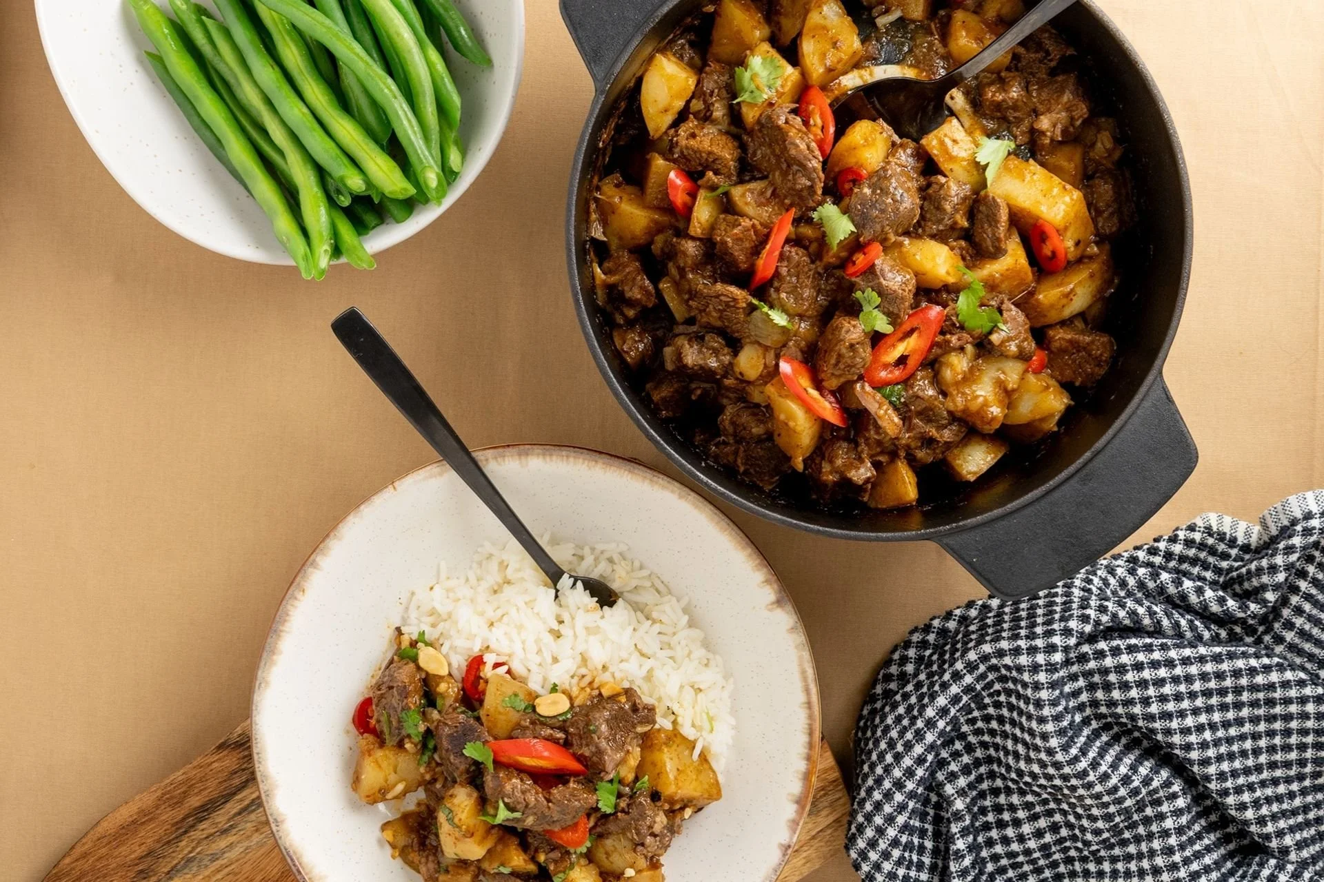 Slow-cooked diced beef and potato curry with red chilli and fresh coriander, served with steamed white rice and green beans.