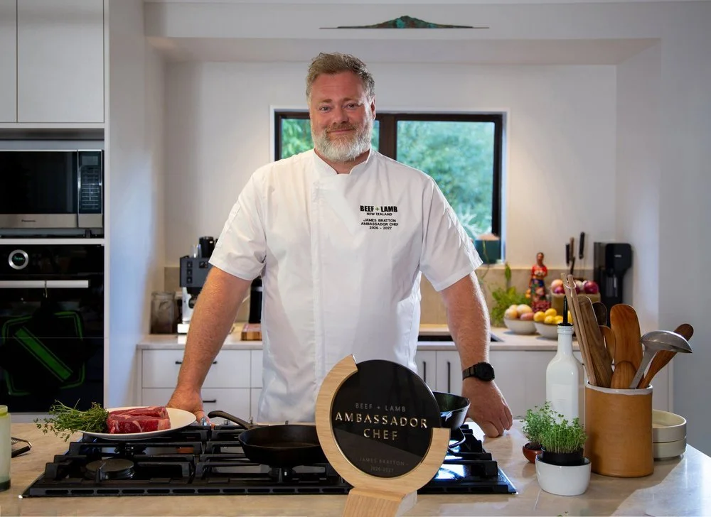chef with grey beard and in a white chef jacket in a domestic kitchen with Ambassador Chef plaque in the front