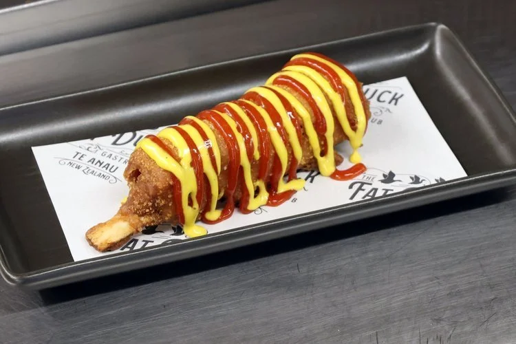 Dean Thompson's lamb rib corn dog drizzled with caramelised chilli ketchup and mustard mayo