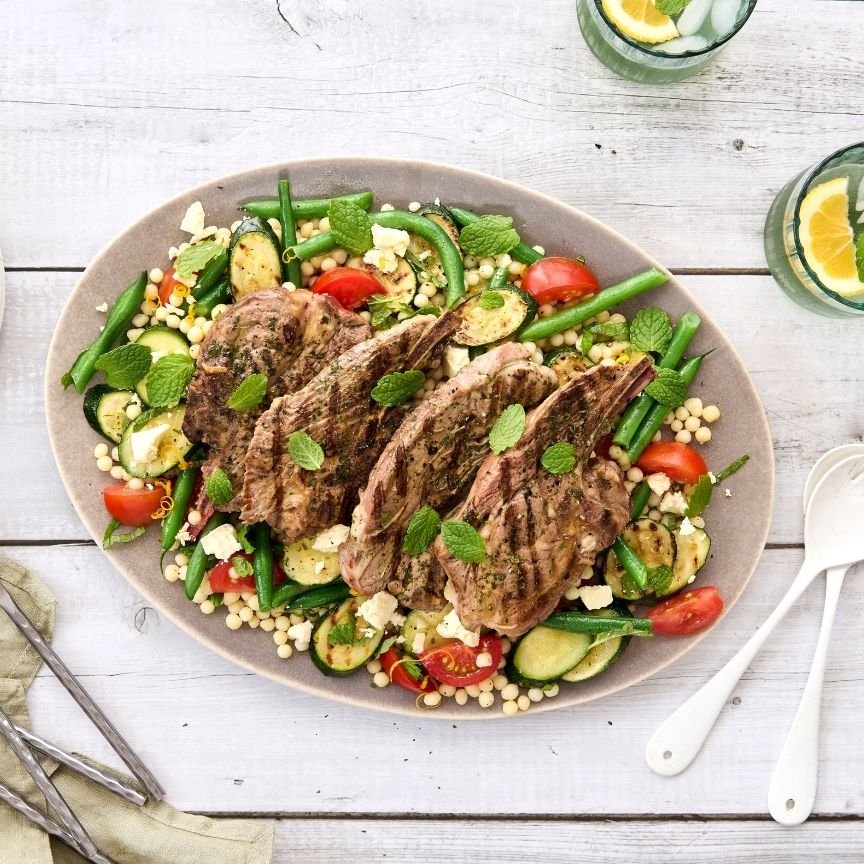 Grilled lamb steaks served on a Mediterranean couscous salad with green beans, courgette, cherry tomatoes, crumbled feta and fresh mint.