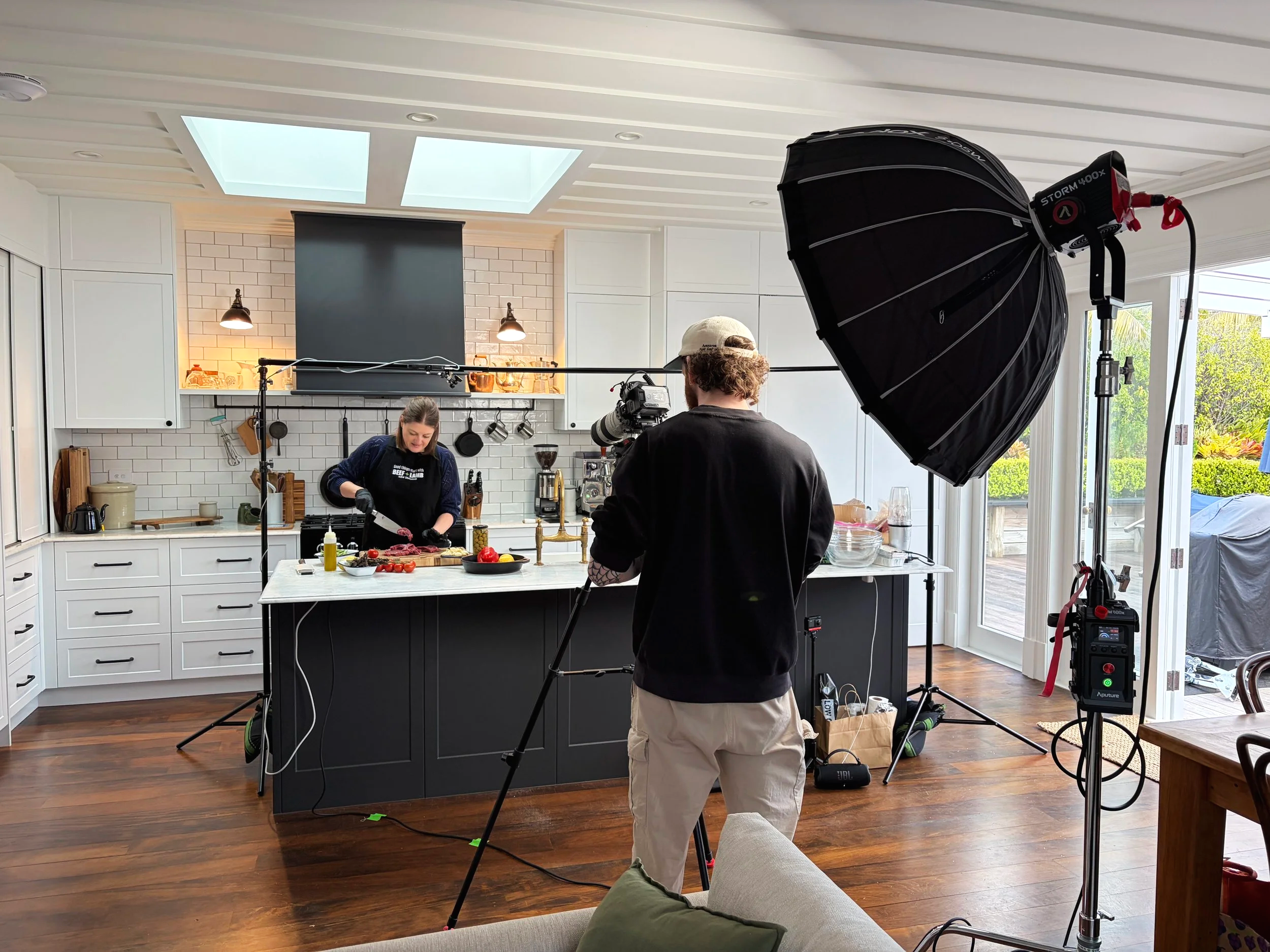 Behind the scenes at a cooking video shoot, with a chef in the kitchen and a camera crew
