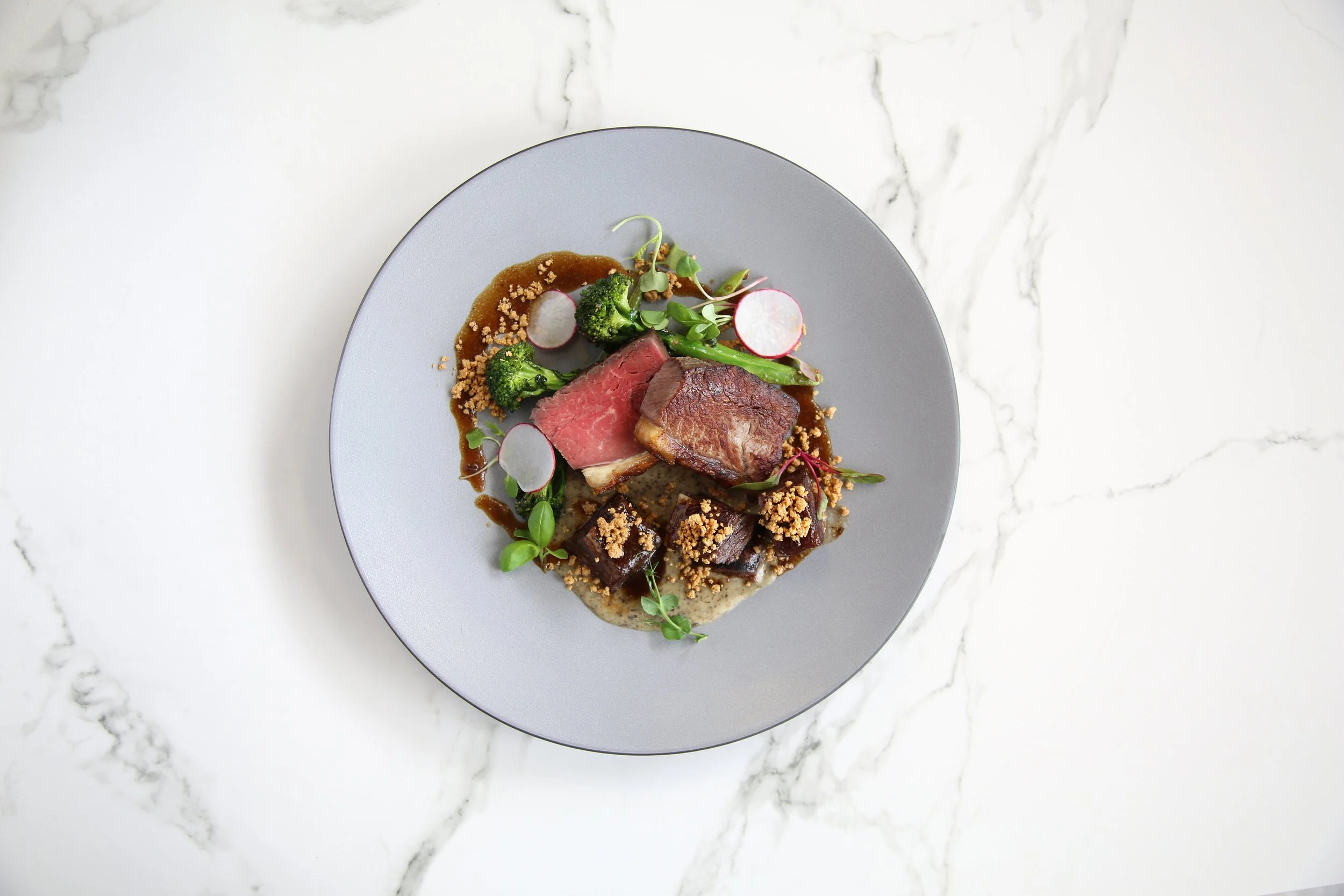 Plated beef sirloin with braised beef short rib and bone marrow butter by chef Dean Thompson