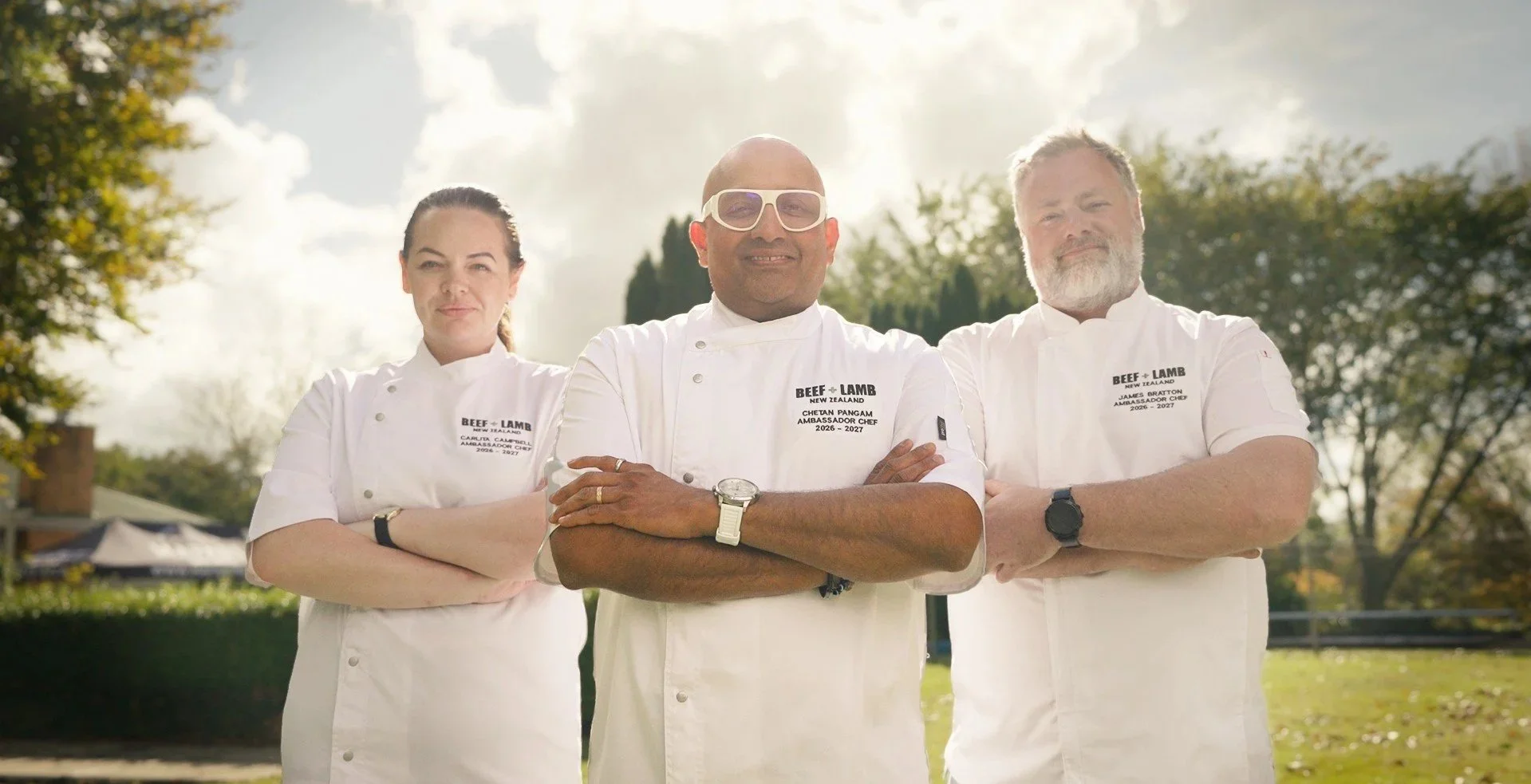 The 2026-2027 Beef + Lamb Ambassador Chefs Carlita Campbell, Chetan Pangam and James Bratton standing arms crossed in their chef whites outdoors