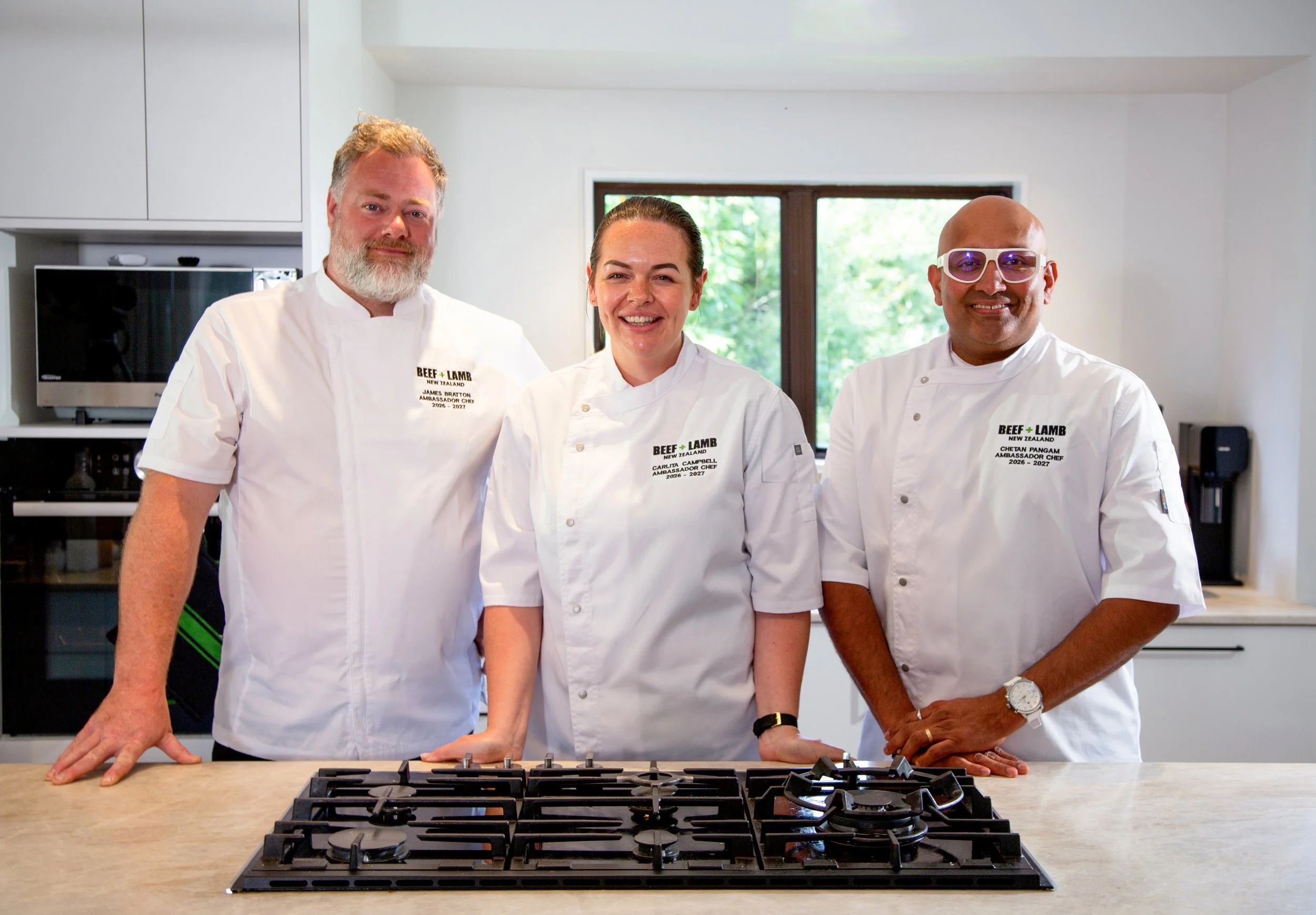 The three 2026-2027 Beef + Lamb Ambassador Chefs smiling together in a kitchen