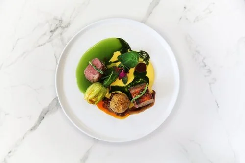 Plated lamb loin with lamb bon bons, marmite dressing and goats cheese hollandaise by chef Mrinal Ghosal