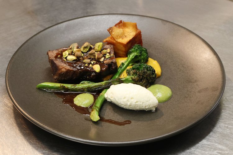 Dean Thompson's 55-day aged porter braised beef cheek with kawakawa chimichurri on a dark plate
