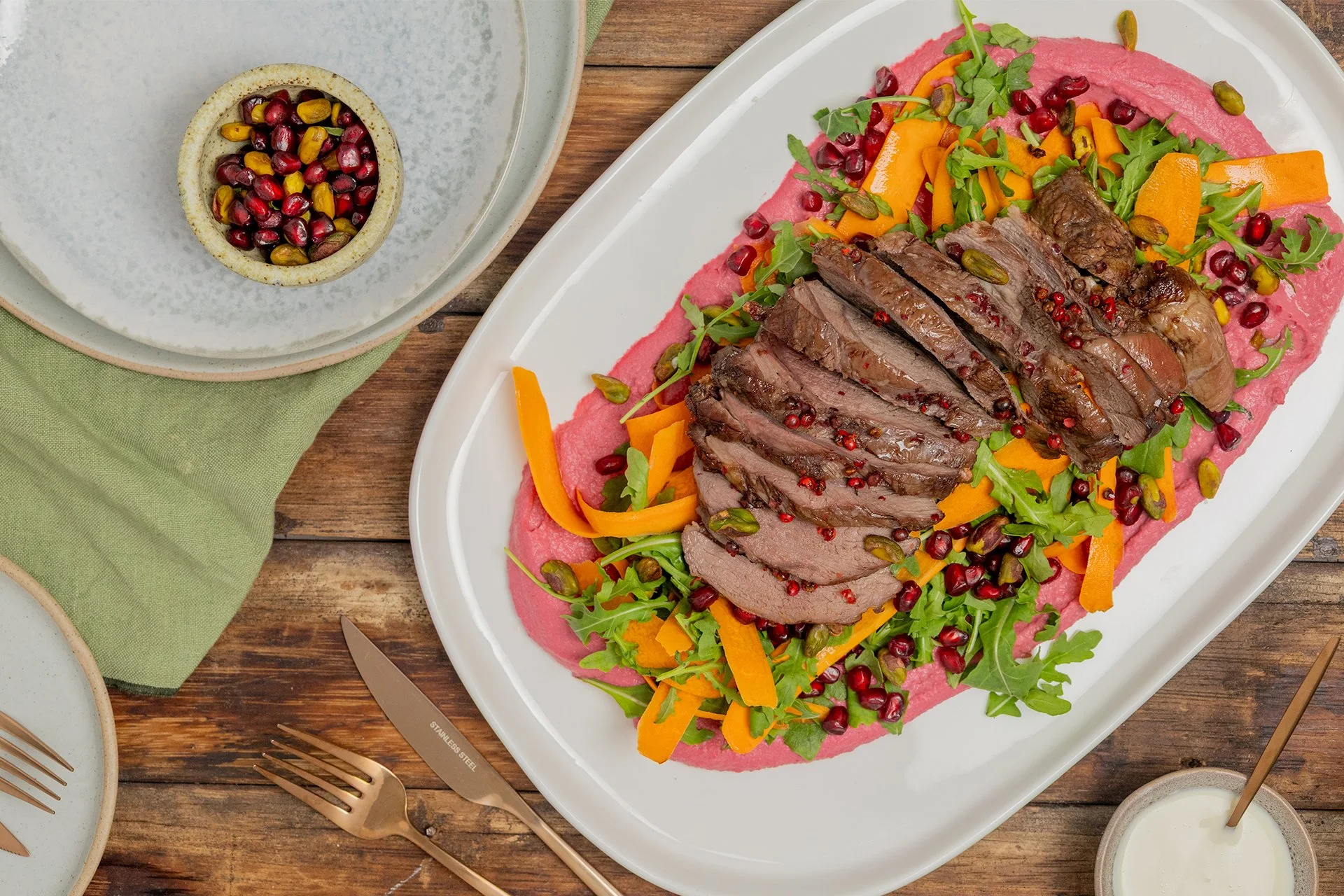 Pink pepper lamb salad with carrot and herbs on a platter