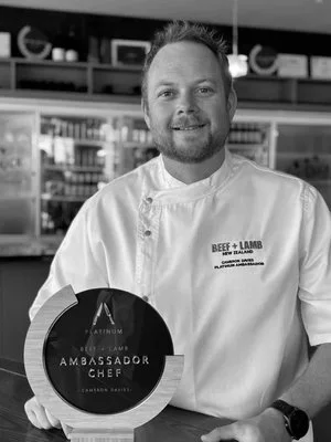 Portrait of Platinum Ambassador Chef Cameron Davies holding his Ambassador Chef award