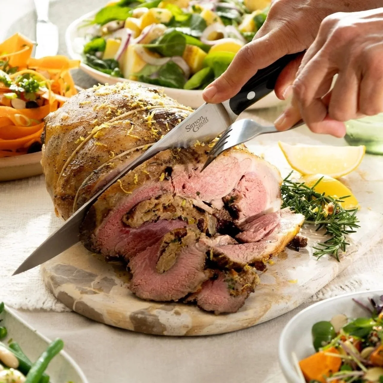 Hot cross bun stuffed boneless lamb leg being carved