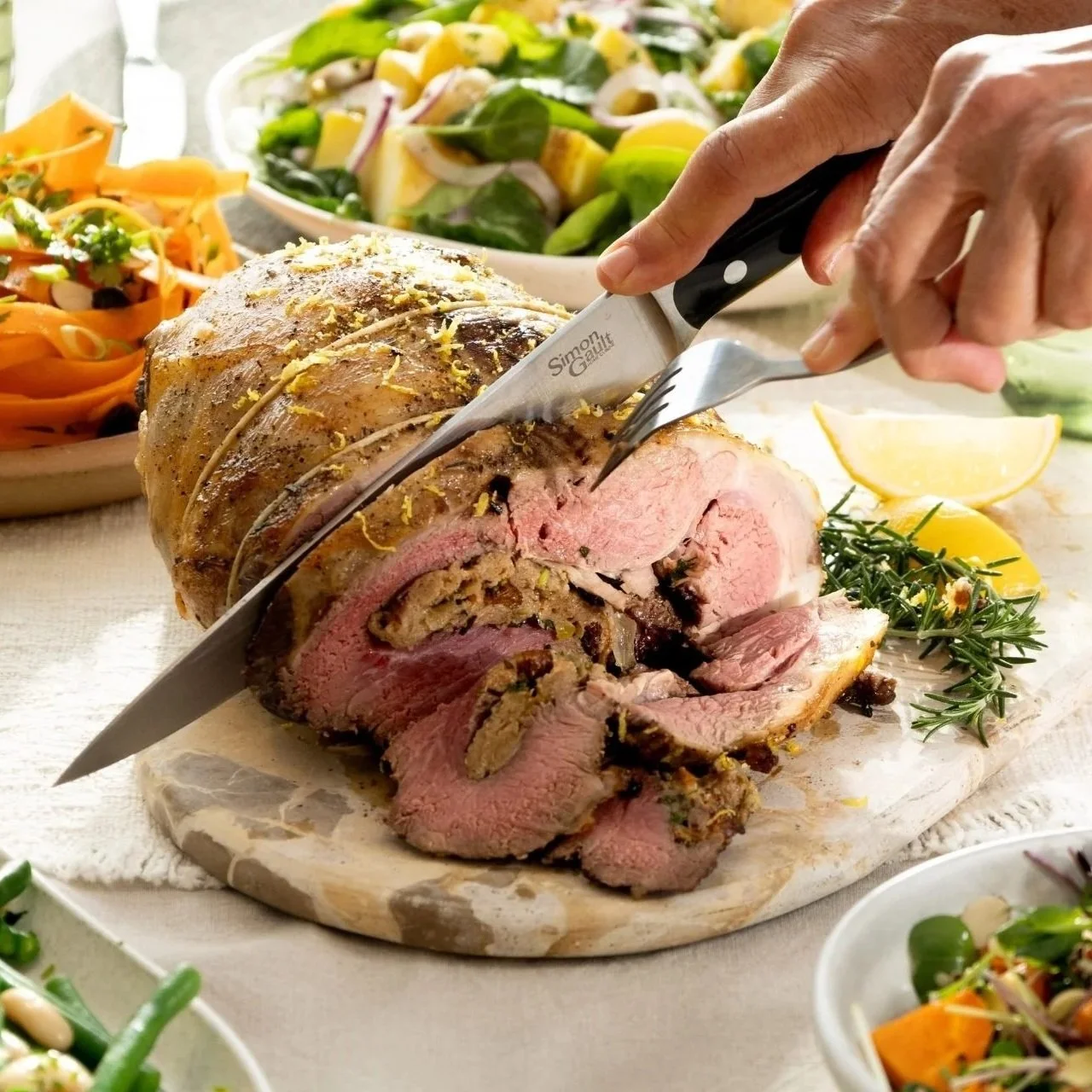 Hot cross bun stuffed boneless lamb leg being carved