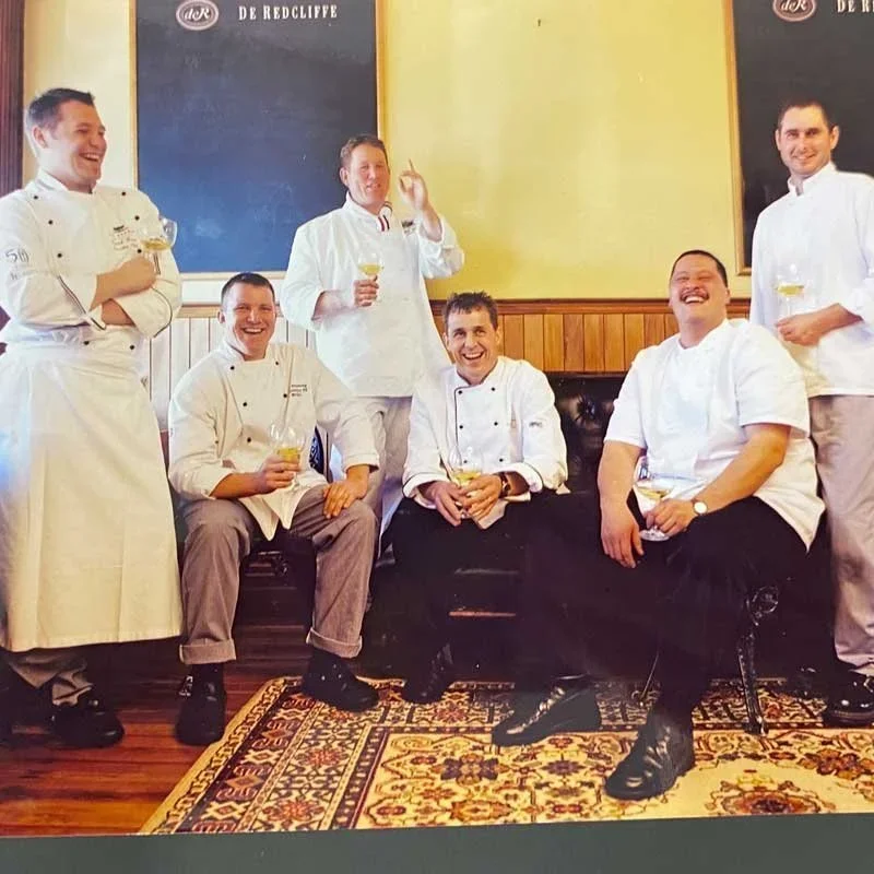 Archive photo of a group of chefs in whites posing in a restaurant dining room
