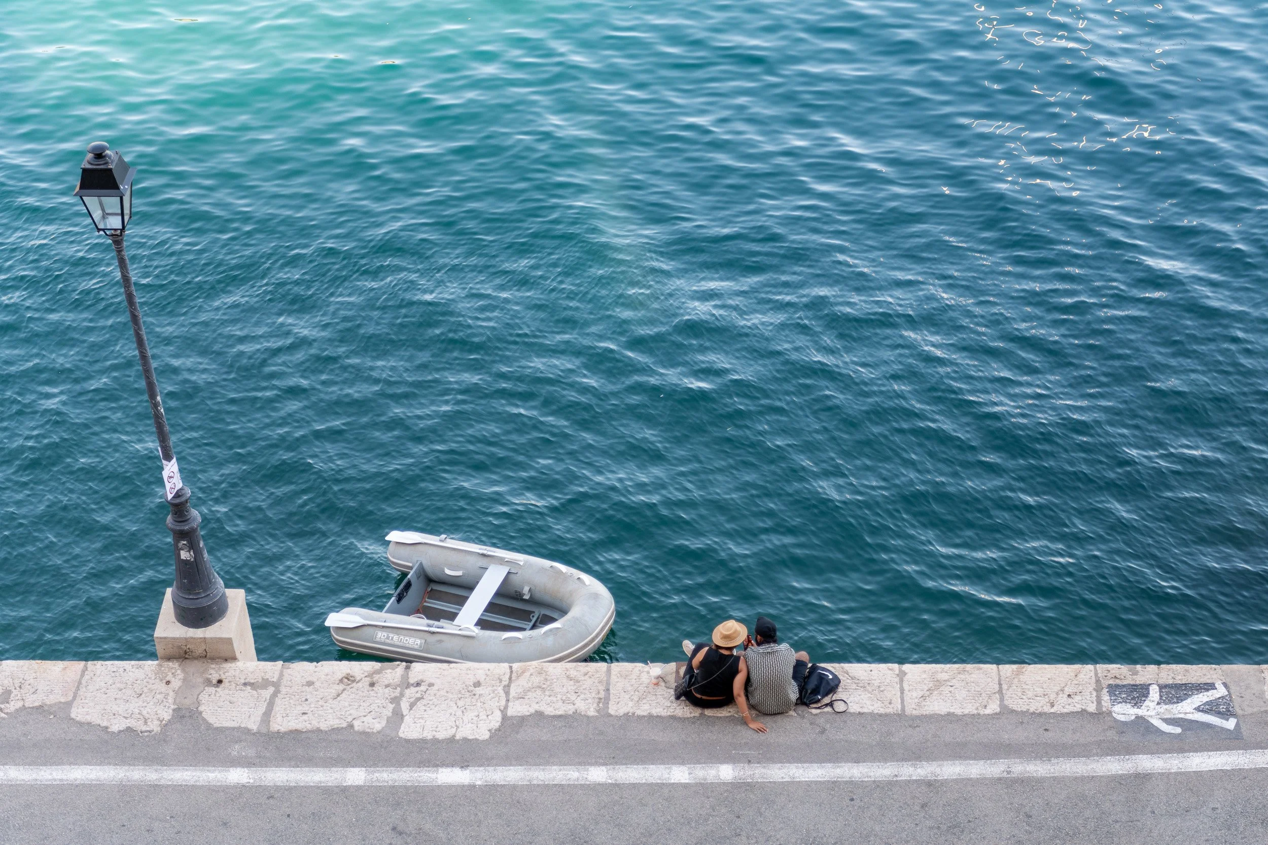 Joe Zlatnik destination photographer - couple seated on harbor wall Antibes France