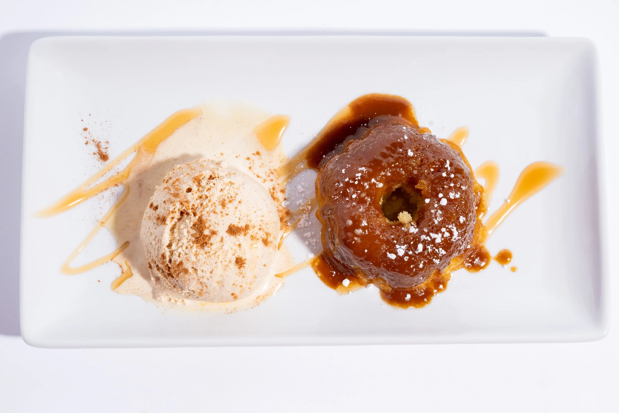 Sticky toffee pudding with caramel sauce and ice cream, restaurant dessert photography
