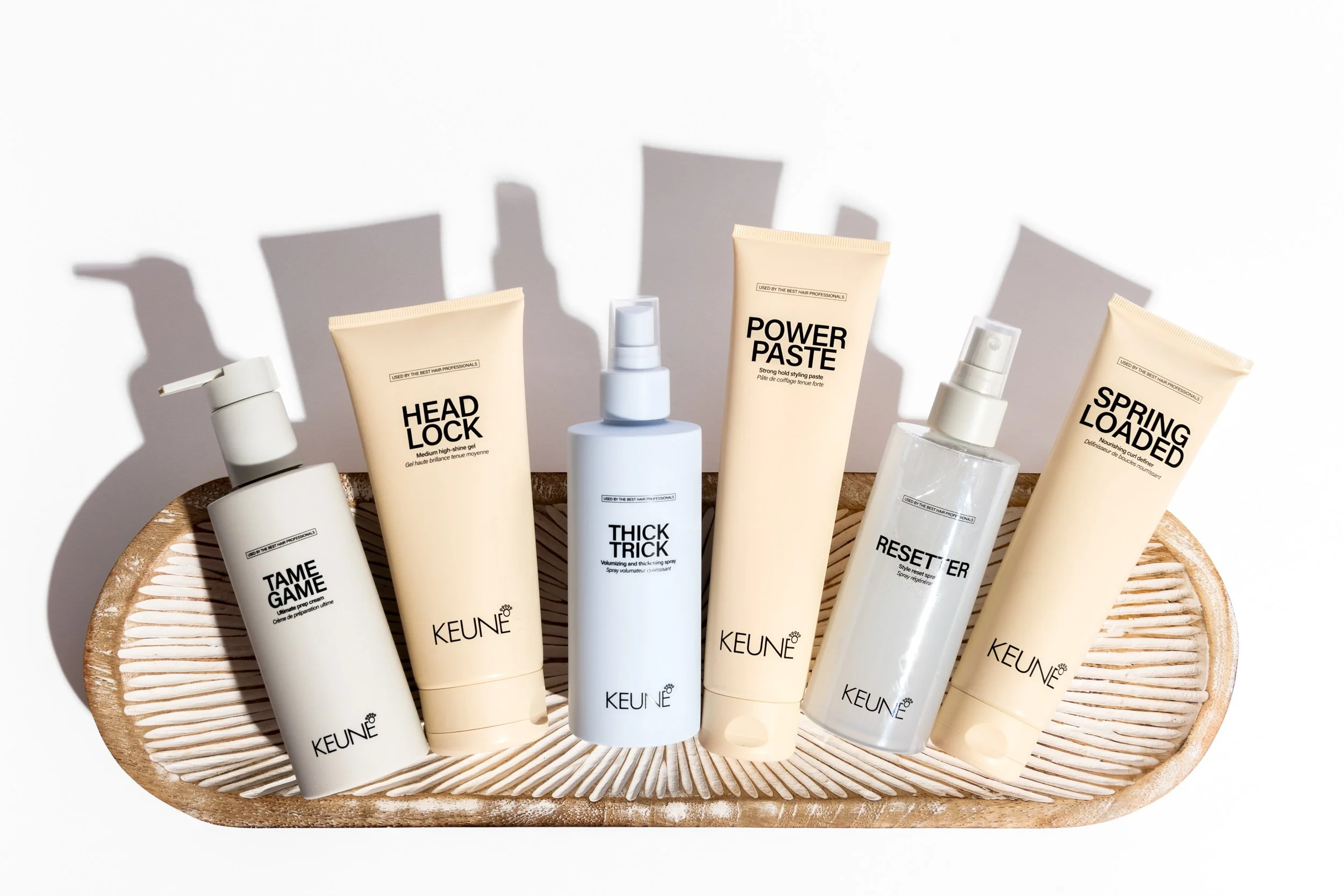 Six Keune hair care products arranged in a woven decorative tray