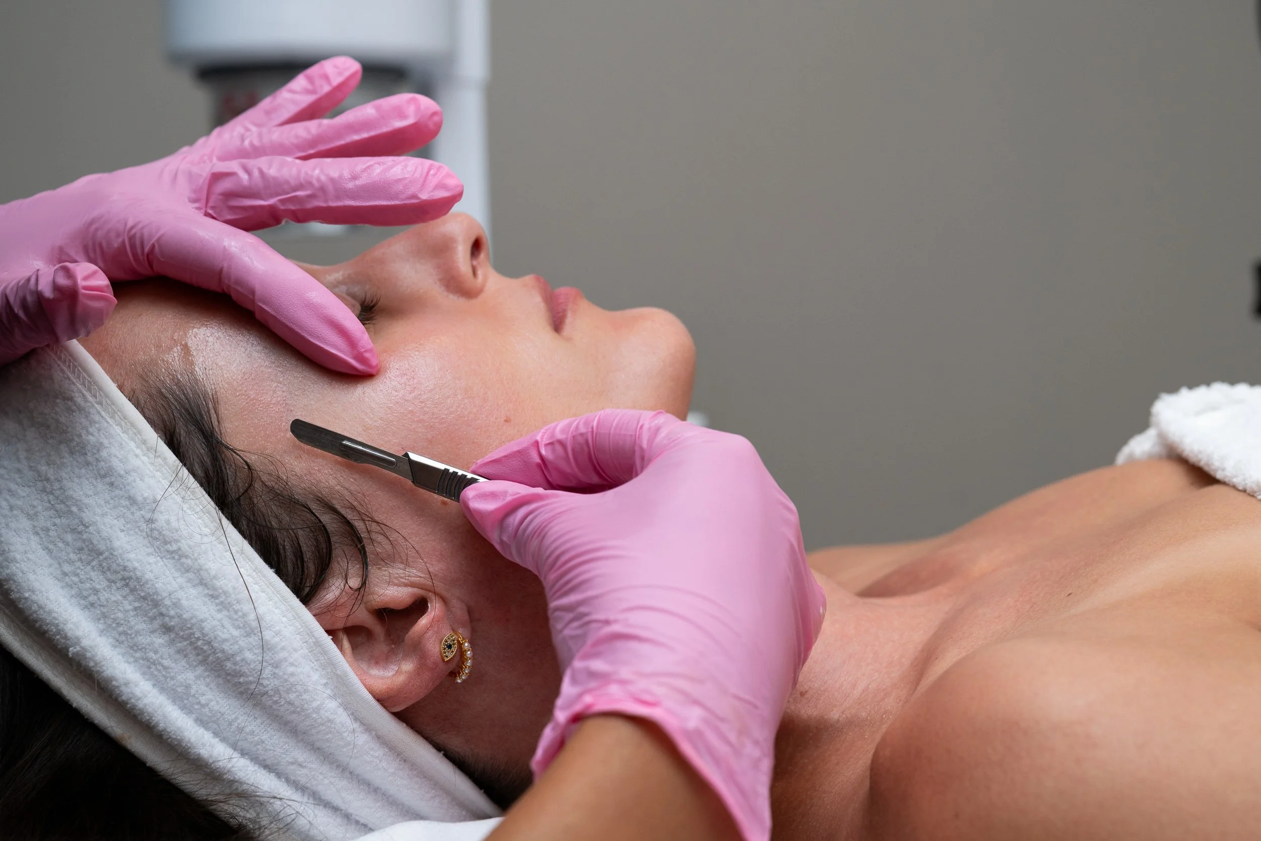 Medical aesthetics provider administering a cosmetic facial treatment.