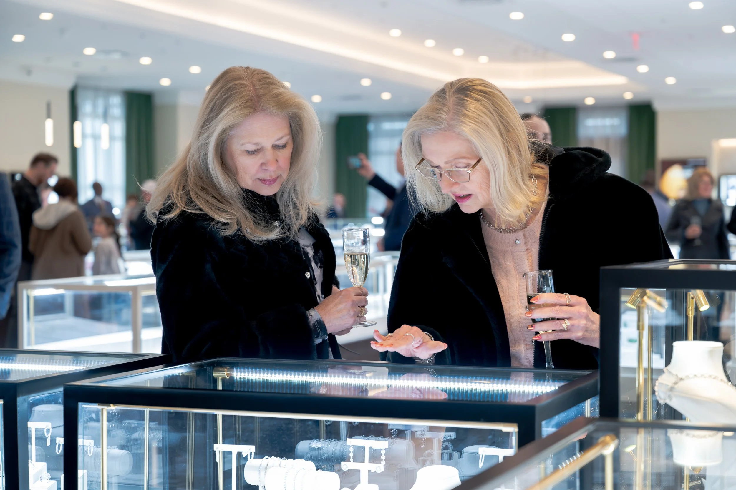 Customers browsing jewelry displays inside the Karats Jewelers showroom.
