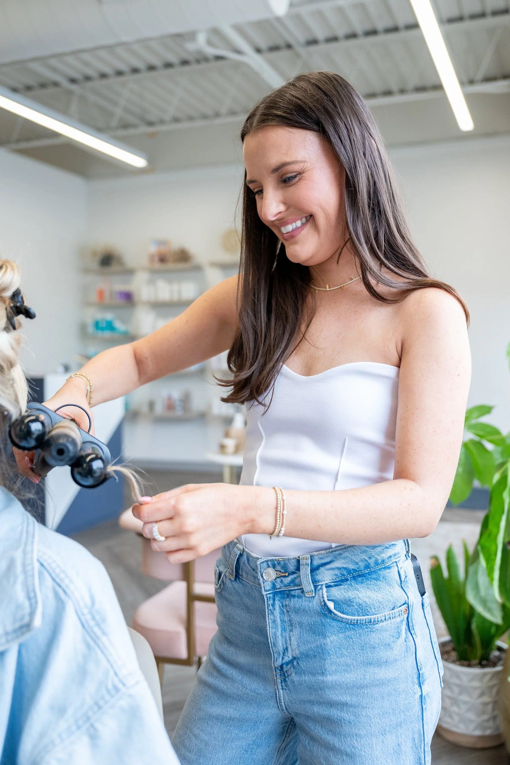 Young woman smiling while a practitioner works on her arm with a device