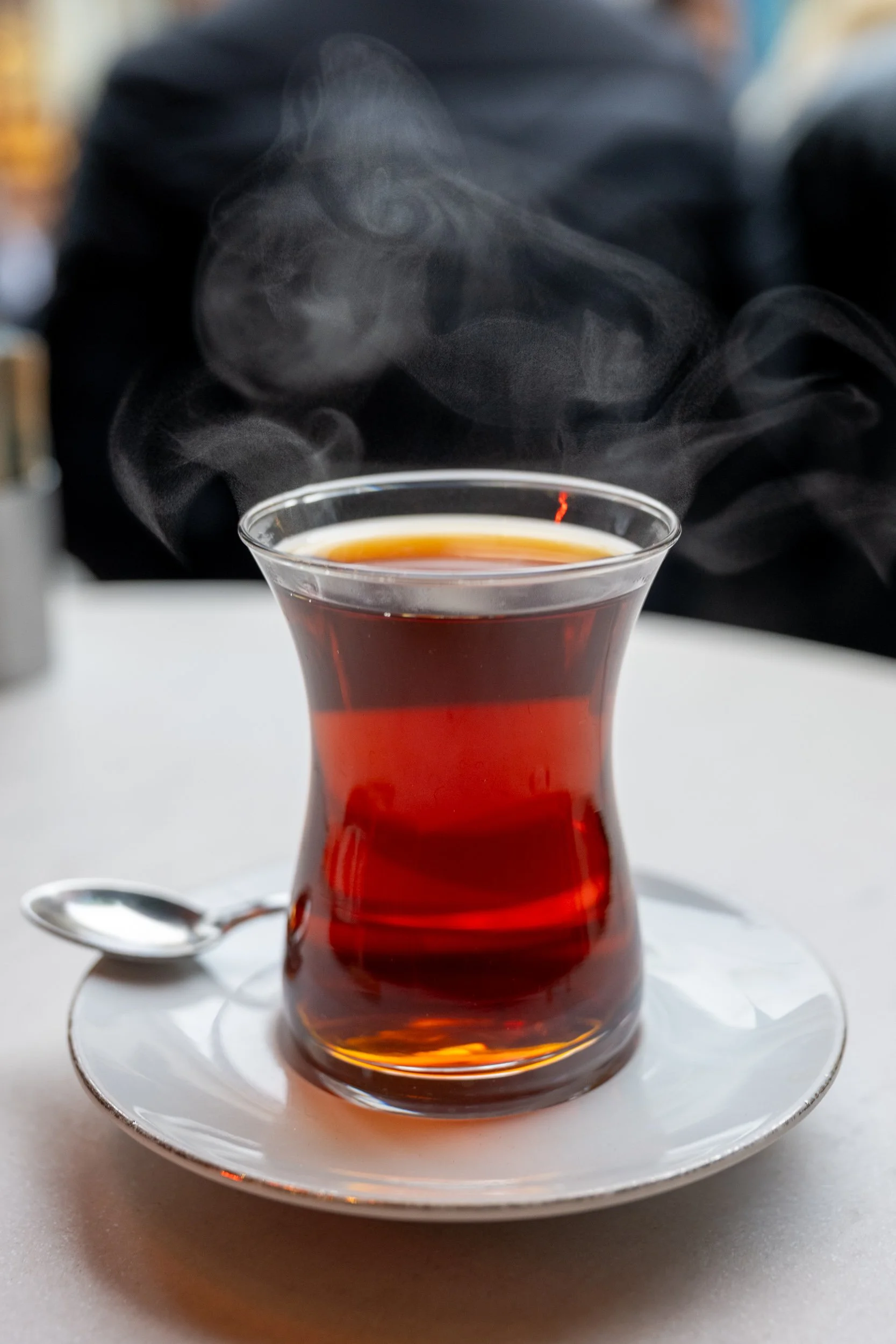 Steam rises from a traditional glass of Turkish tea, capturing a fleeting moment of warmth and hospitality.