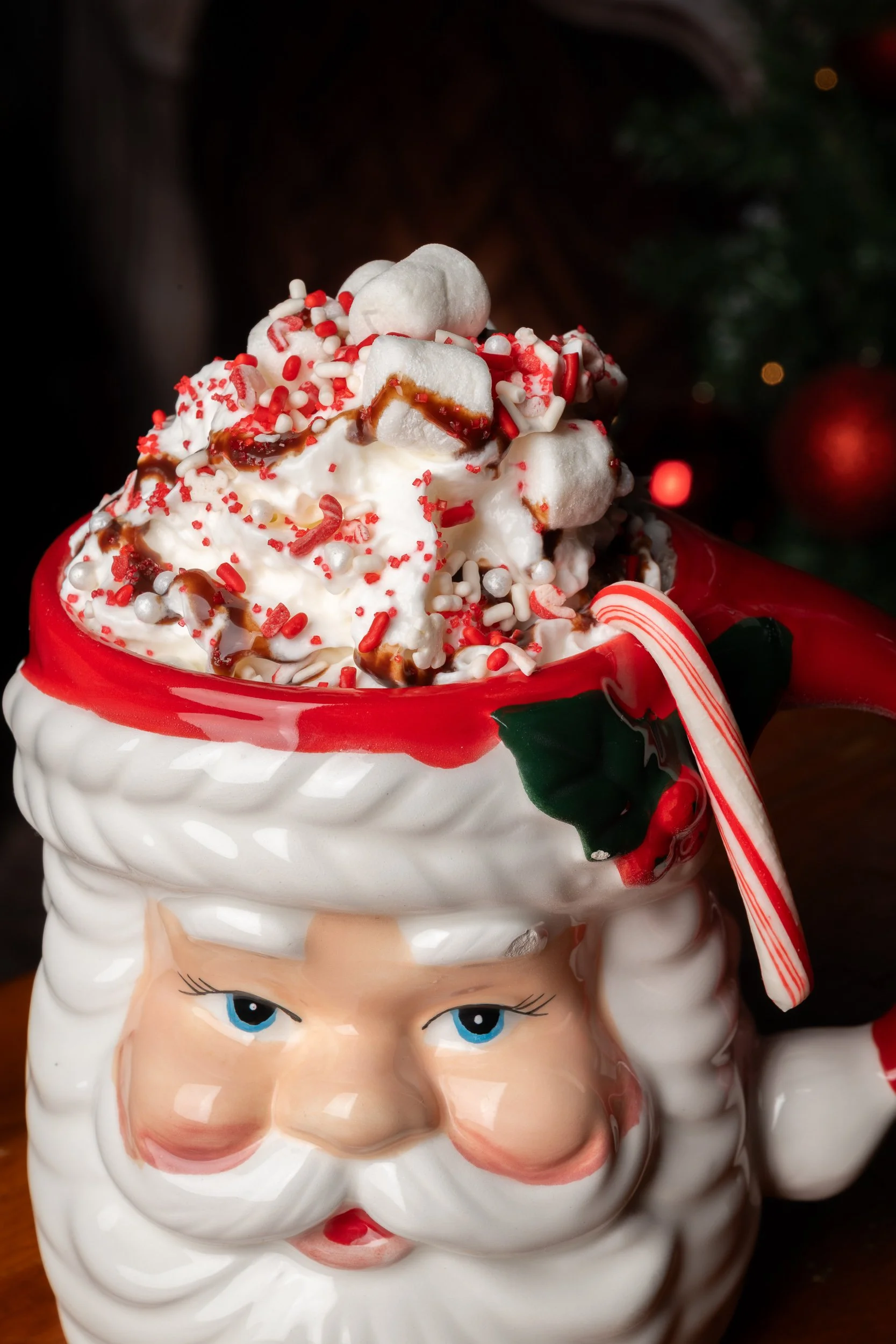 Santa Claus mug with whipped cream candy cane and holiday garnish, seasonal restaurant beverage photography
