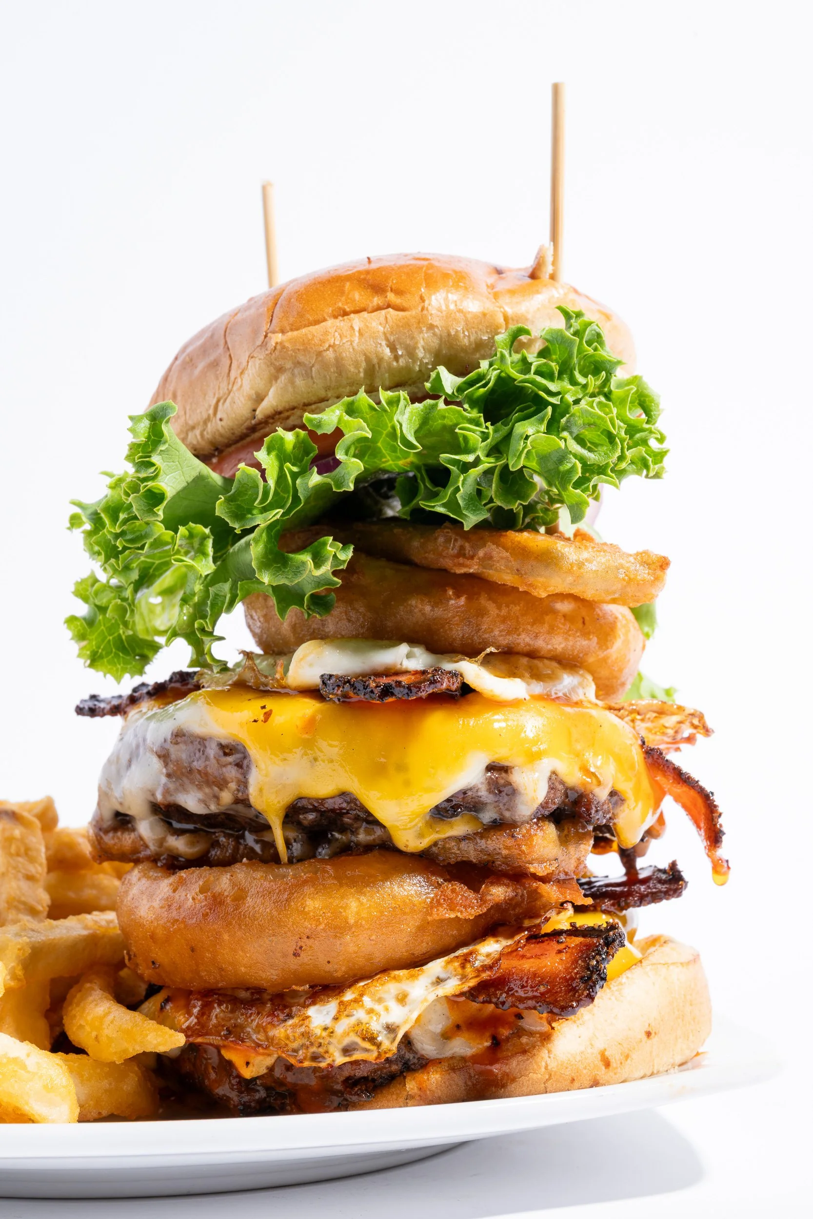 Stacked double cheeseburger on white background, restaurant menu food photography
