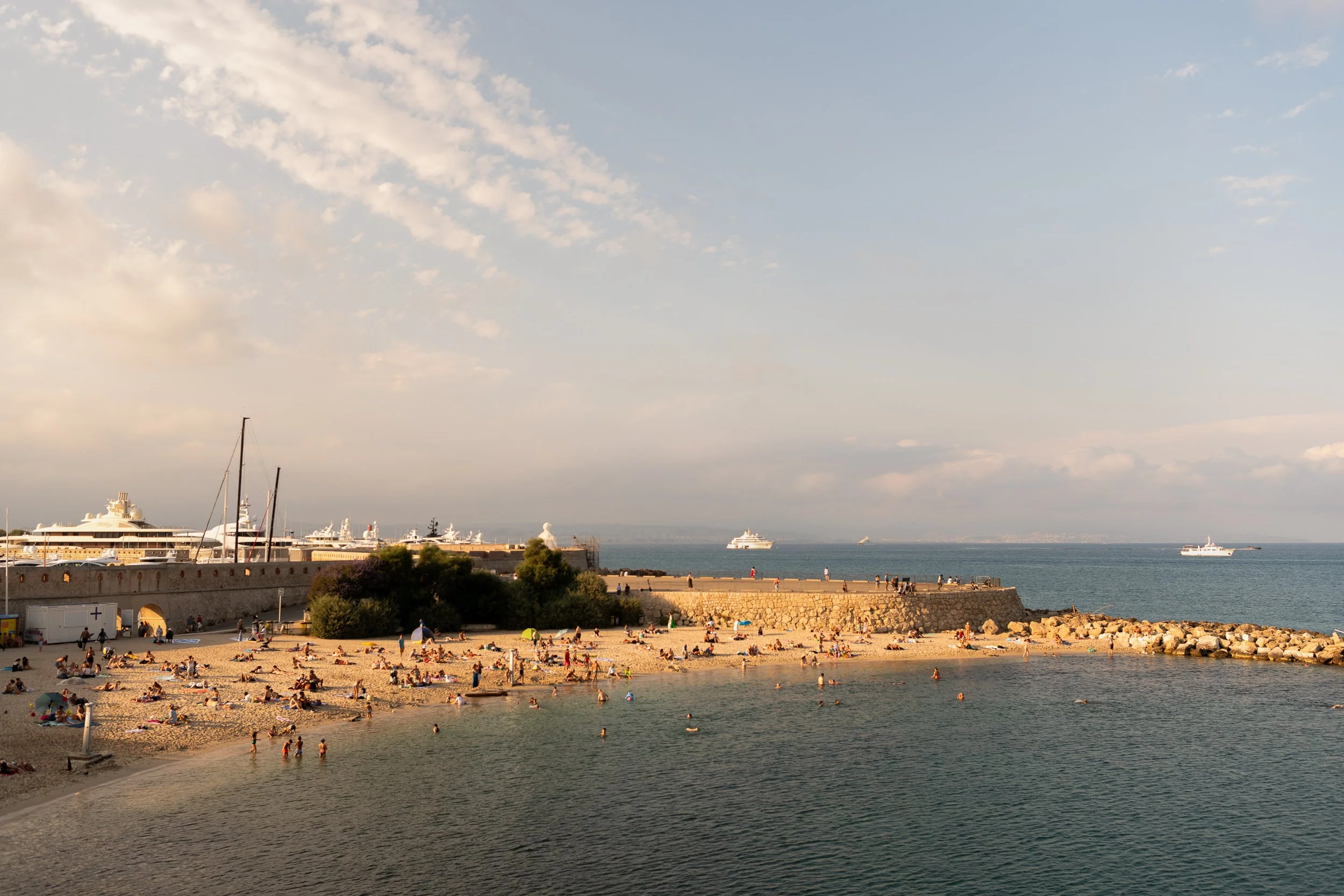 Antibes beach from above, Mediterranean Sea, yachts and a cruise ship anchored offshore.
