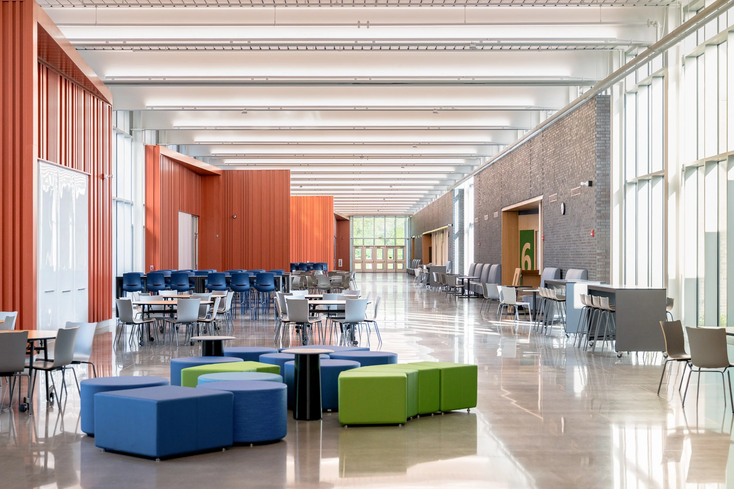 Bright open commons area of a modern school with colorful modular furniture
