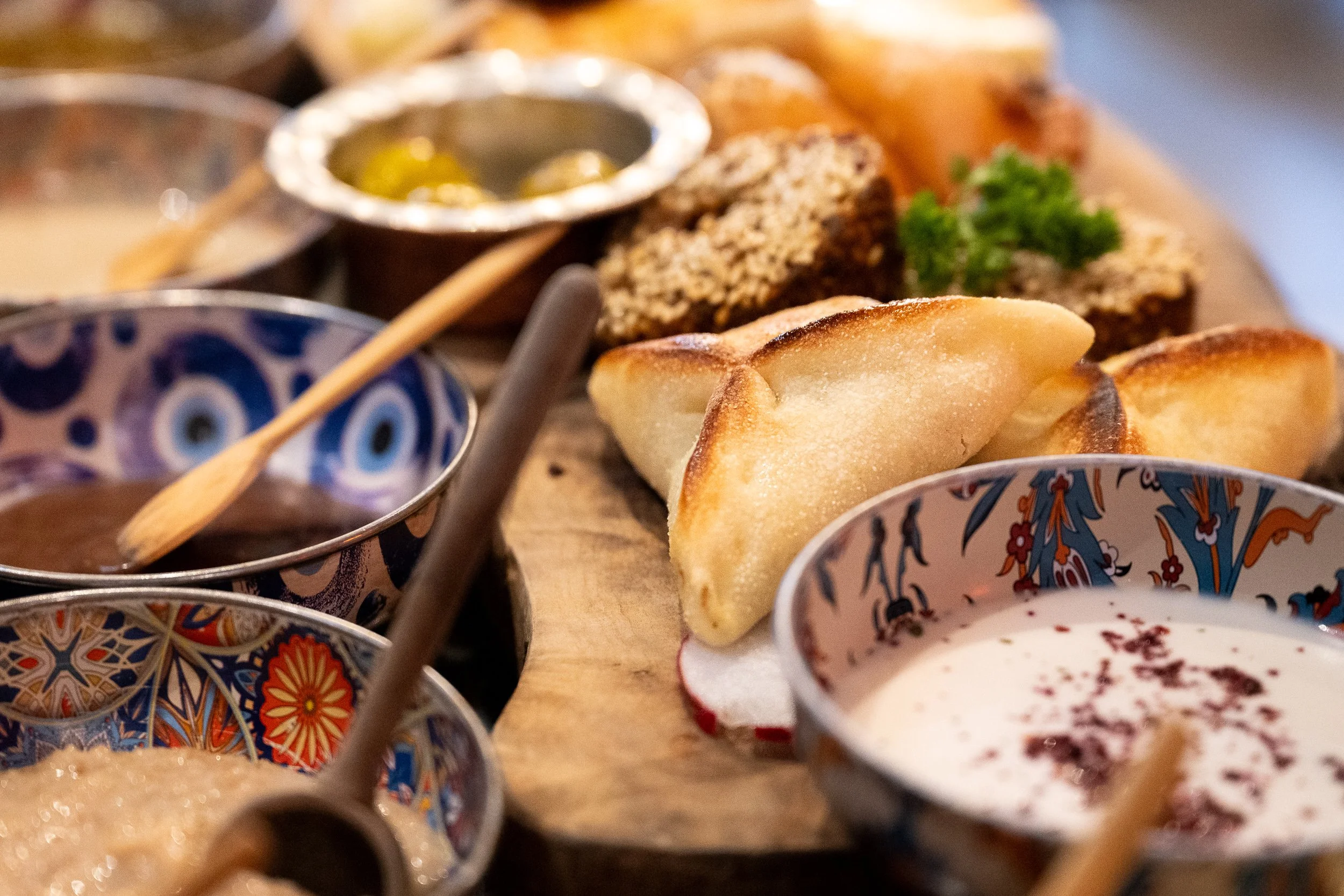 Fresh pastries and colorful mezze invite the viewer into the textures and flavors of a shared meal.