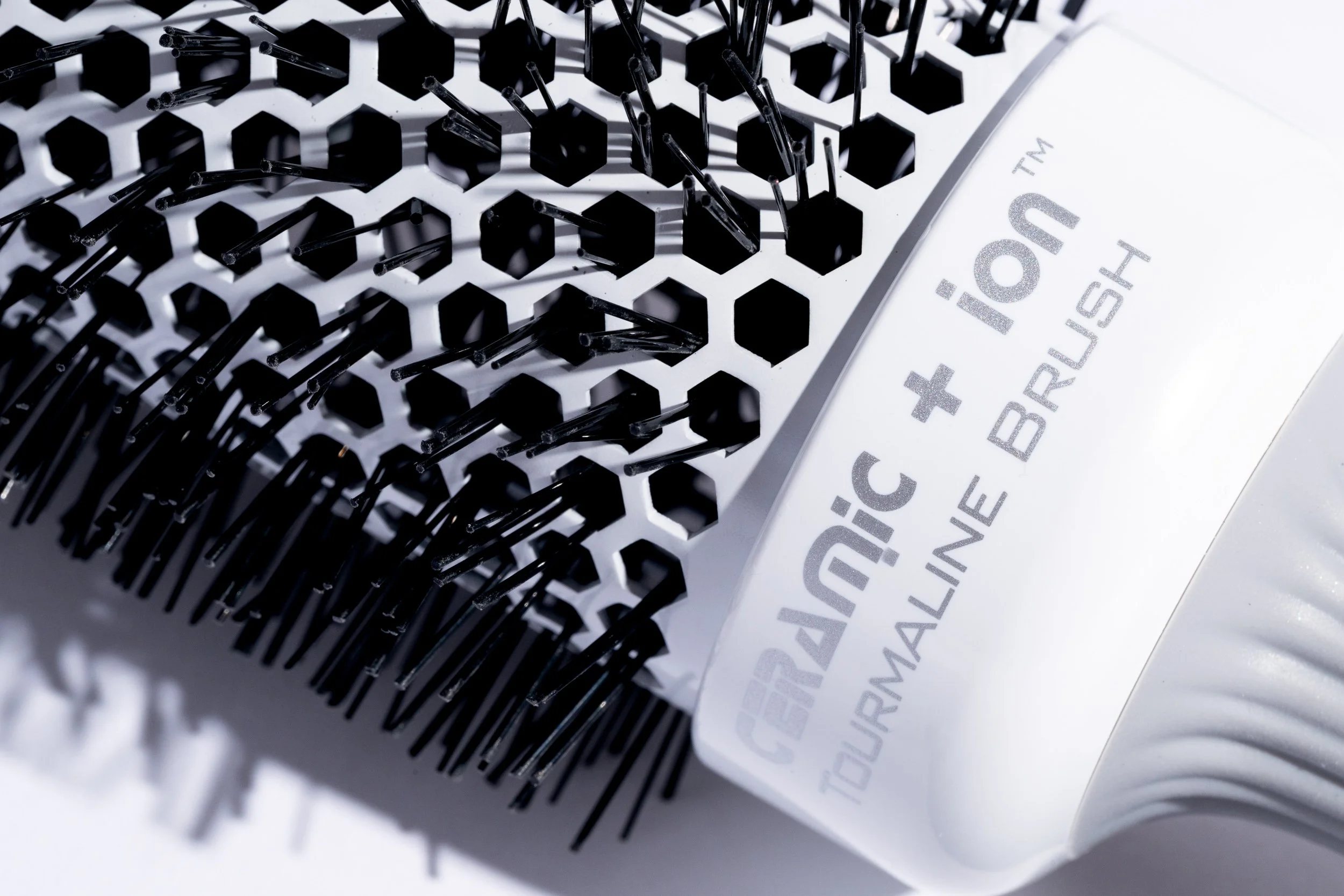 Extreme close-up of a ceramic tourmaline hair brush showing bristle and barrel detail
