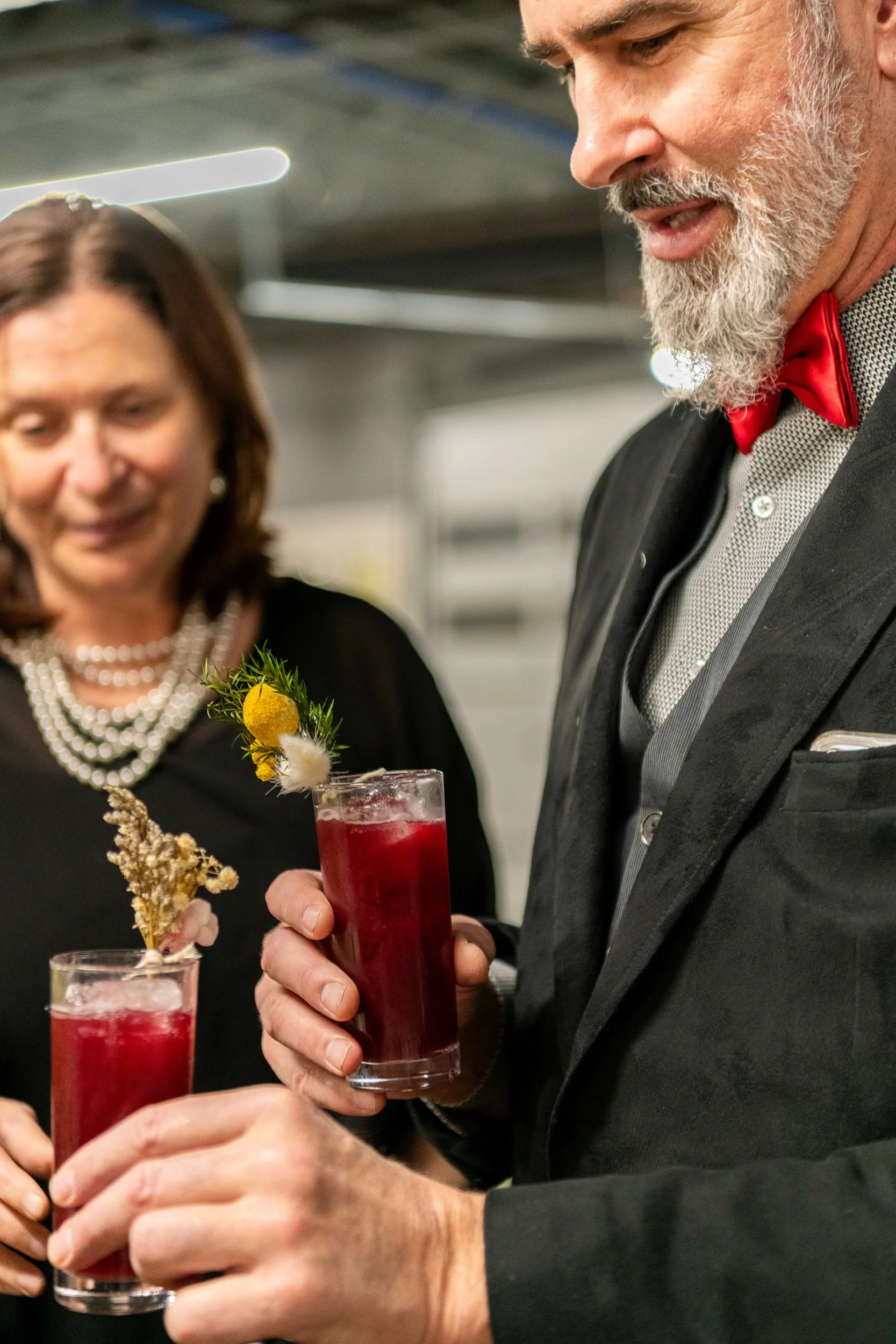 Couple in formal attire receiving craft cocktails at fine dining dinner event
