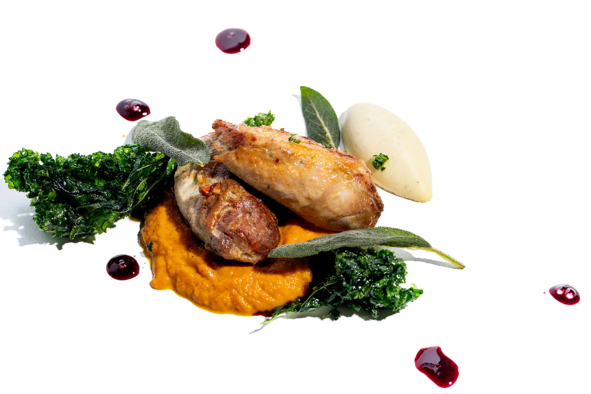 Roasted poultry on carrot puree with kale and cherry gastrique, fine dining plate presentation

