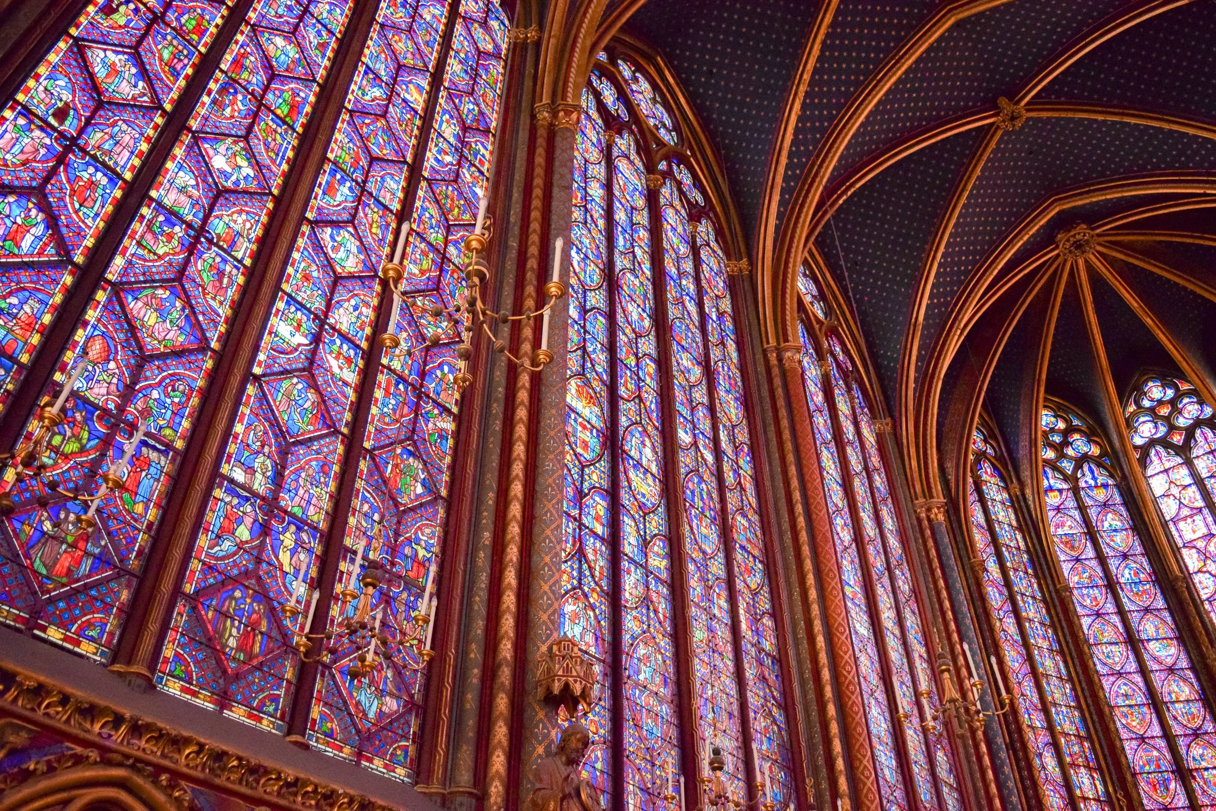 Sainte-Chapelle interior, Paris, France — floor-to-ceiling stained glass windows and Gothic stone vaulting.