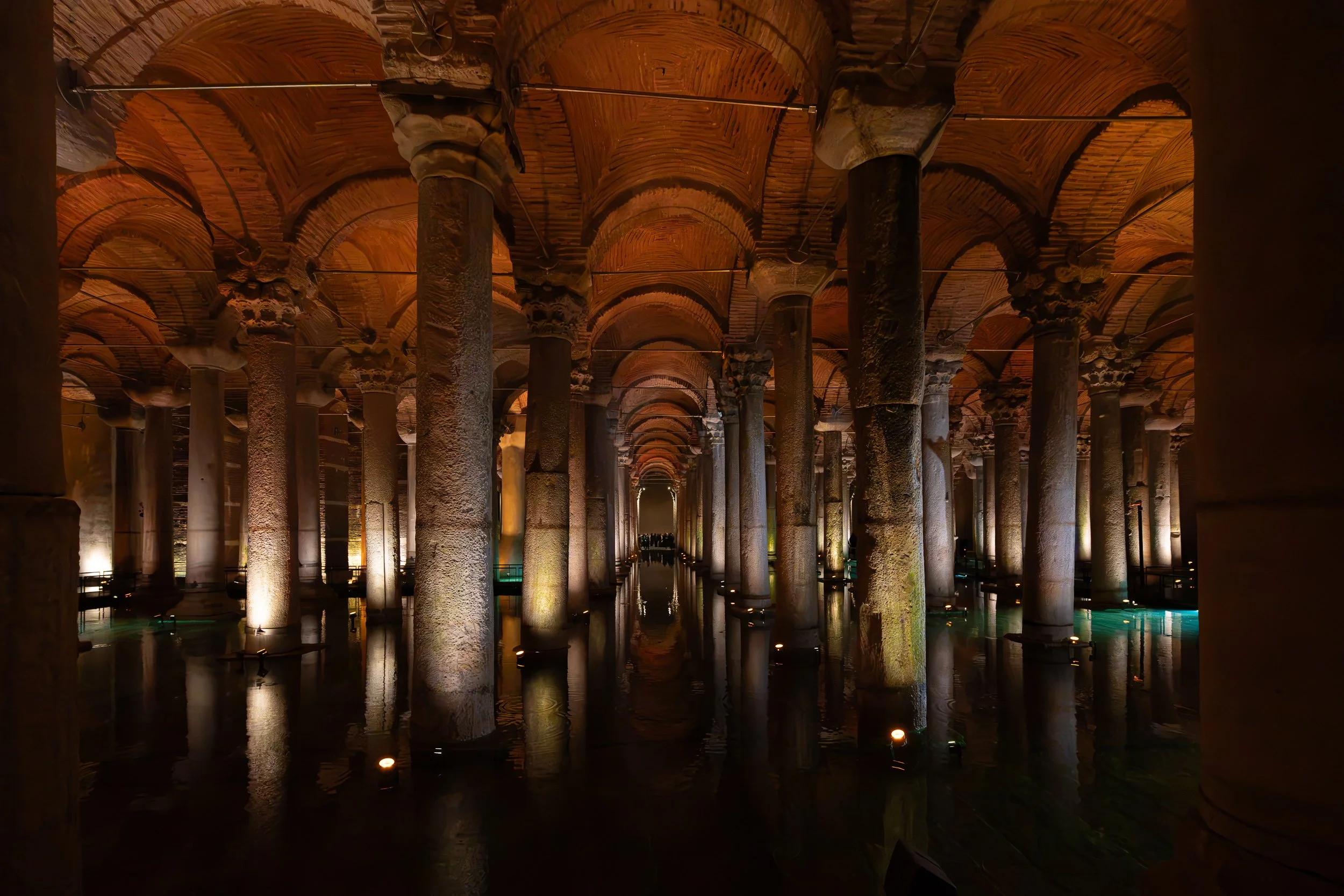 Endless rows of illuminated columns stretch across still water, revealing the scale and mystery of an ancient underground reservoir.
